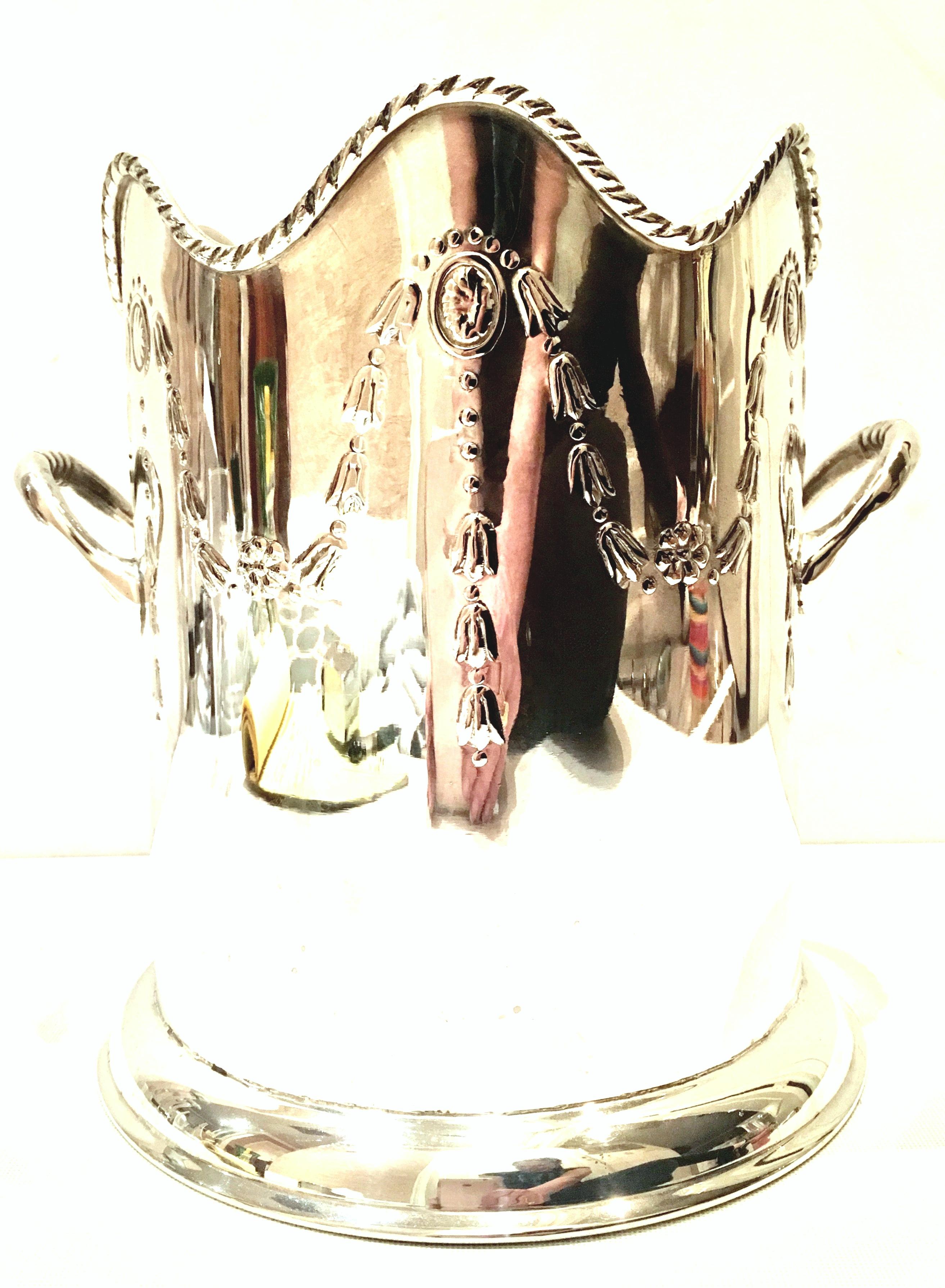 20th Century silver plate neoclassical style two handle champagne or ice bucket. Features a high relief swag and rosette medallion pattern with a rope detail scallop top edge.