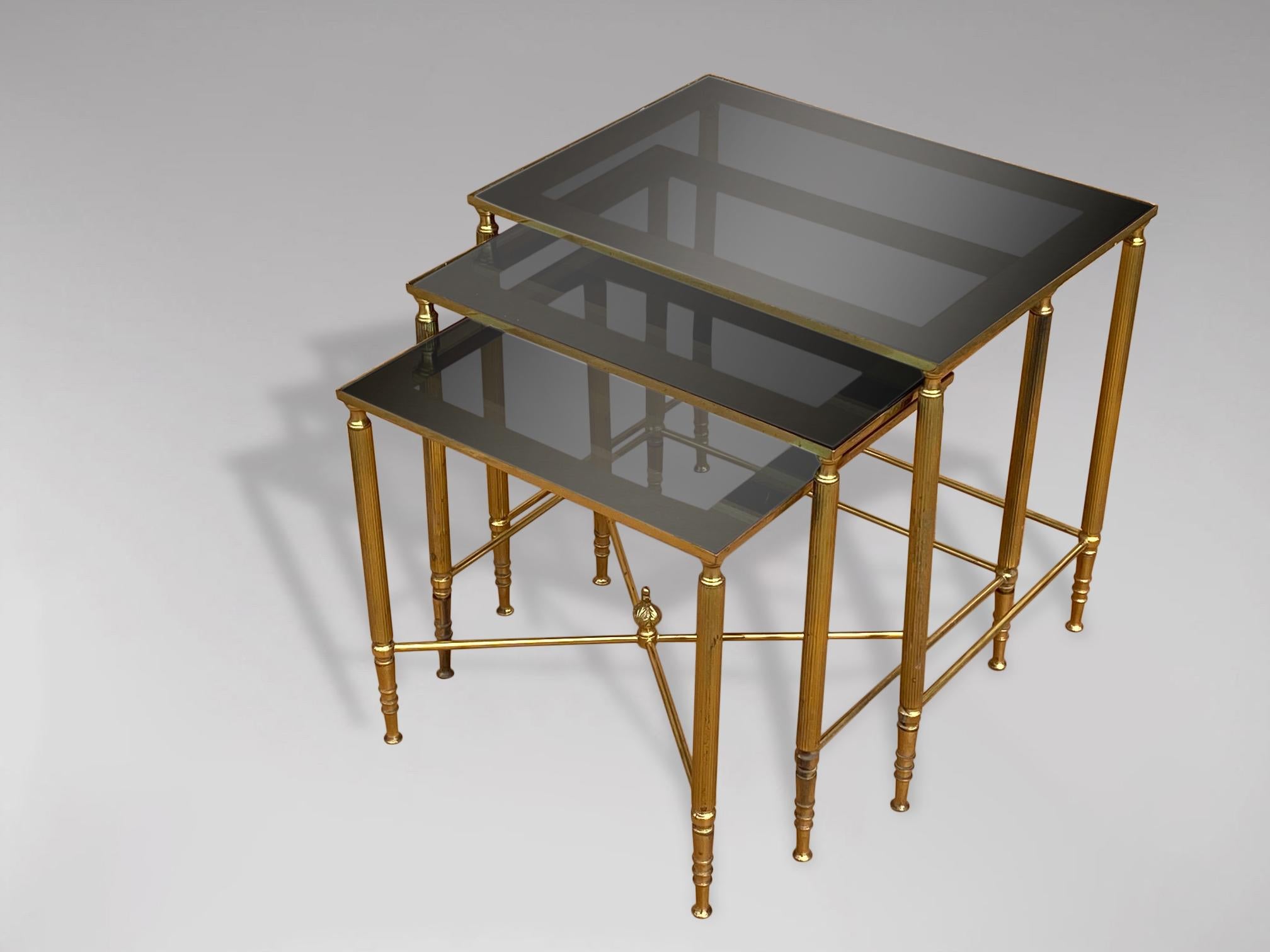 A stunning set of 3 mid 20th century rectangular brass frame nest of tables with inset smoked glass and mirror frame tops. In very good vintage condition. These tables were made in France and date from around the 1960s. 

Dimensions of the large