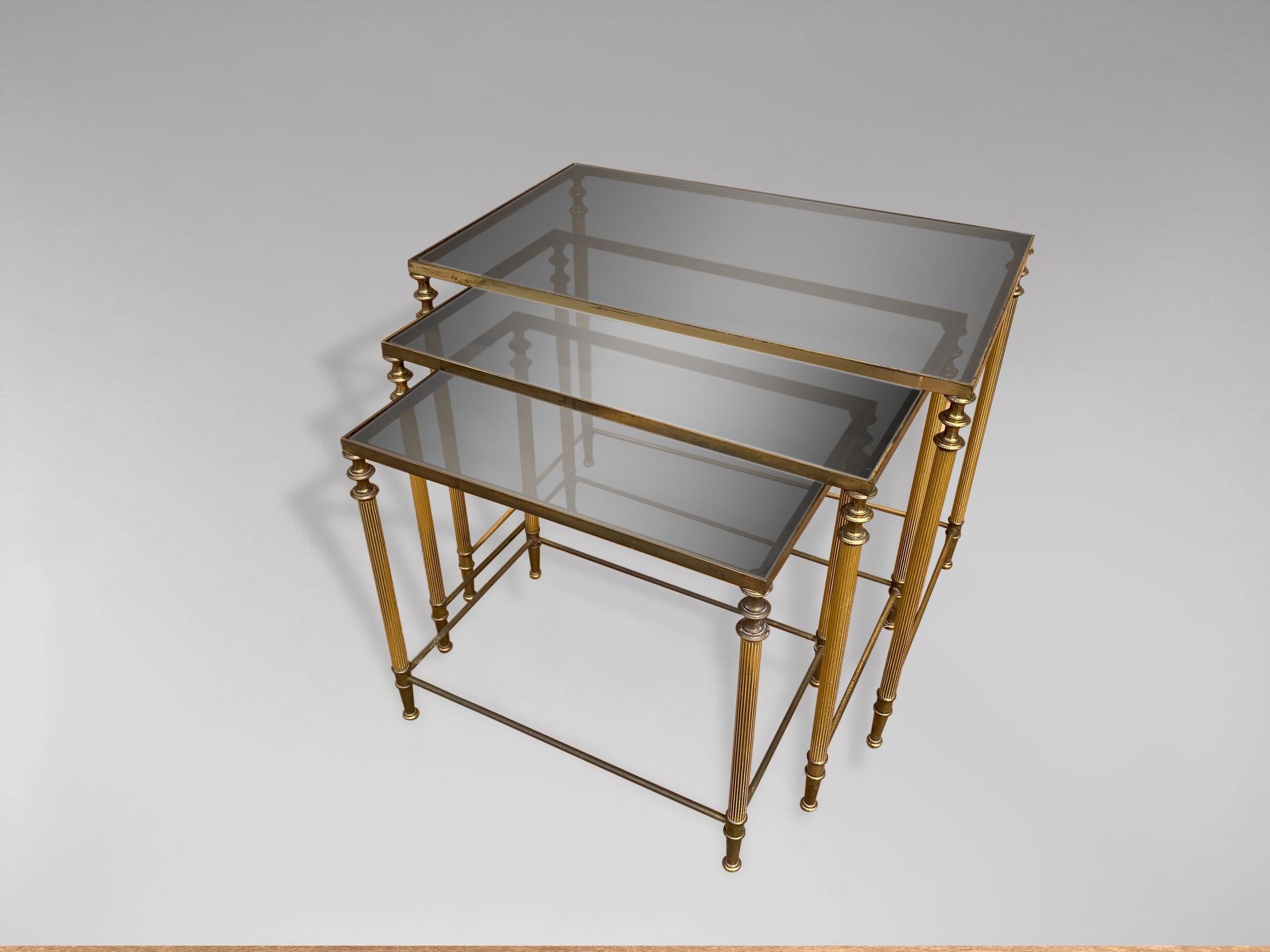 A stunning set of 3 mid 20th century rectangular brass frame nest of tables with inset smoked glass tops. In very good vintage condition. These tables were made in Belgium and date from around the 1960s. 

Dimensions of the large table are 52.5 x