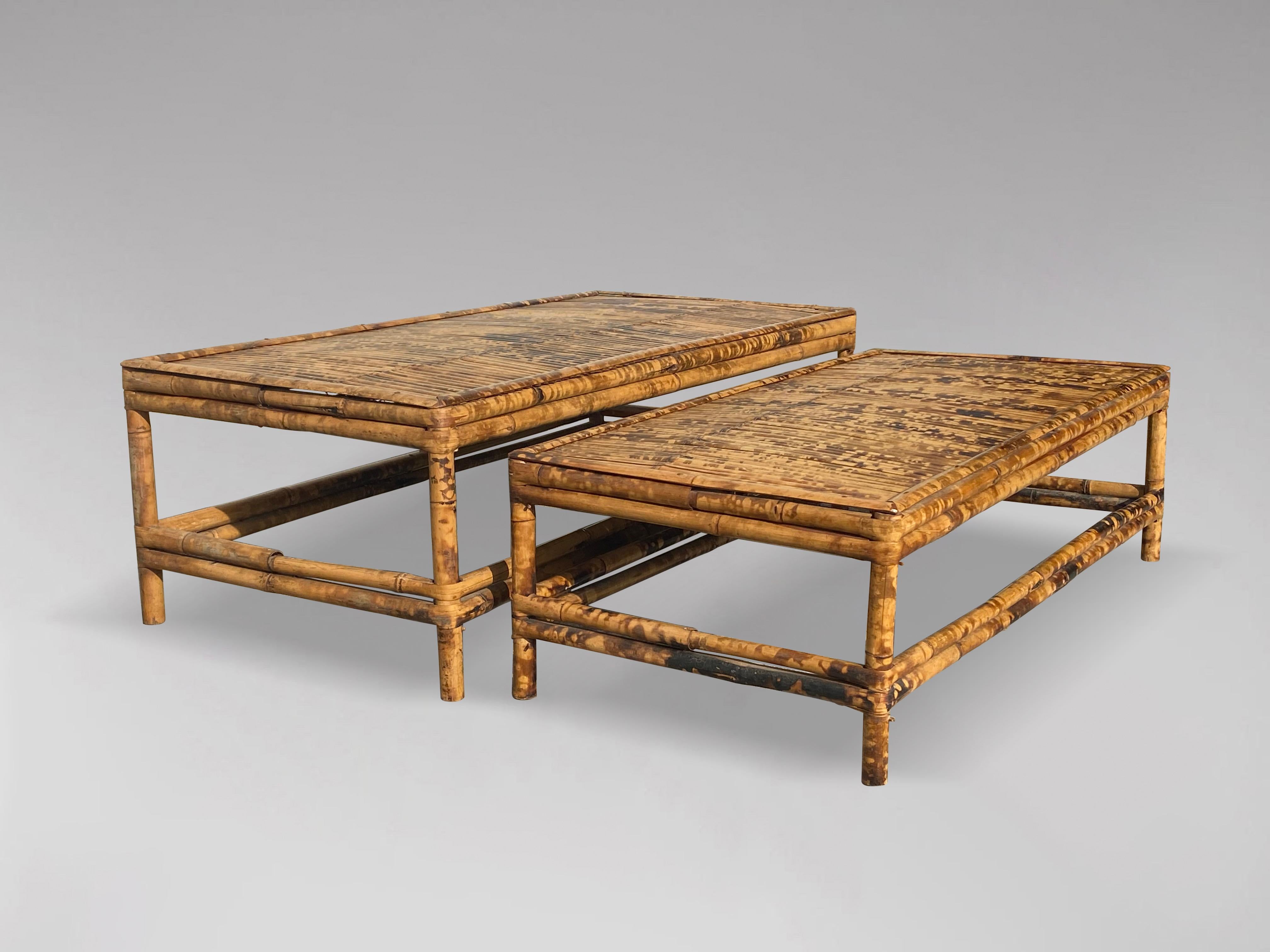 A set of two tortoise bamboo coffee tables from France, dating from the 1960s. The low rectangular bamboo coffee tables featuring a square slatted top sitting above four straight legs connected to one another through side stretchers. Great size and