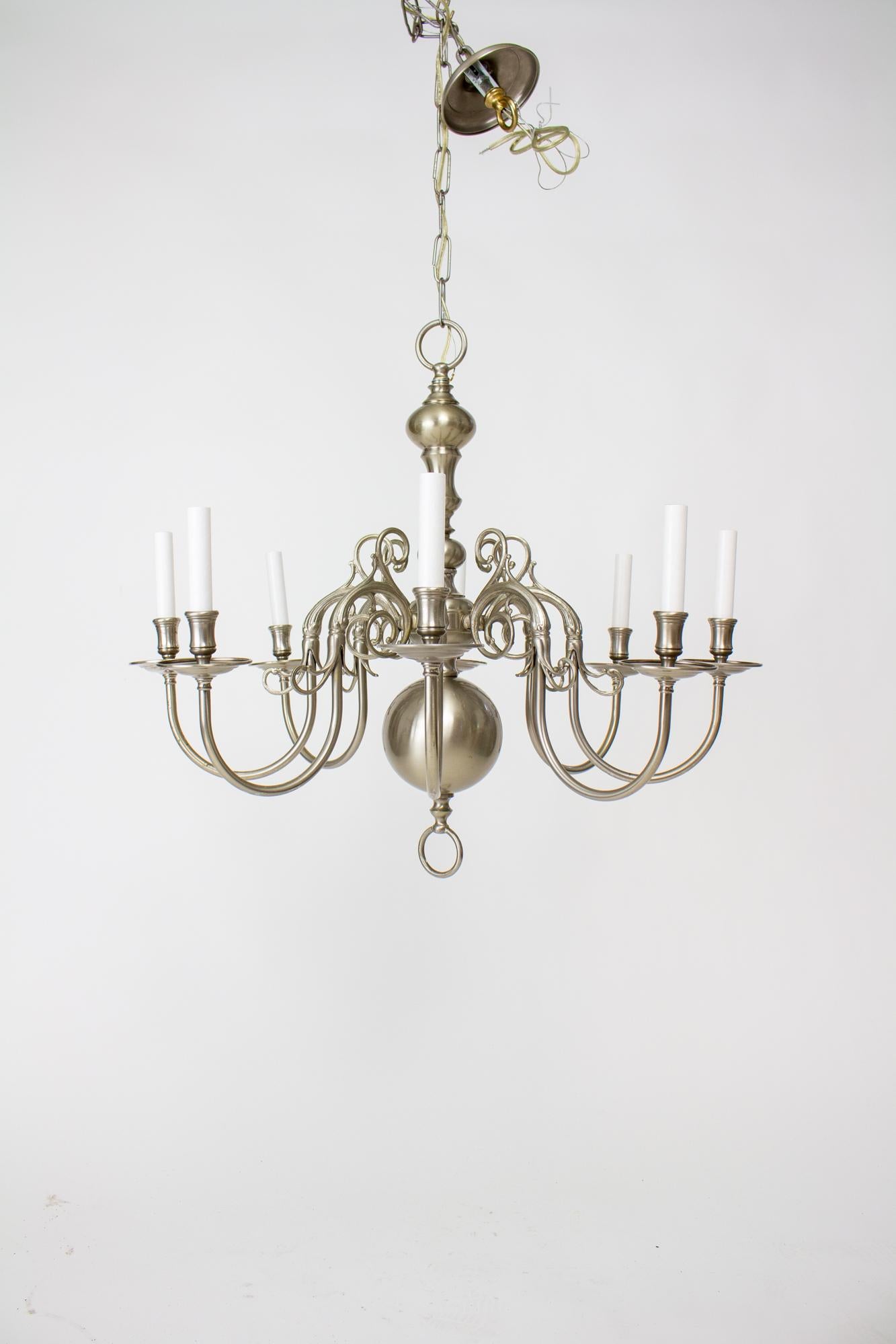 20th Century nickel 8 arm colonial style chandelier. Antique brushed nickel plated finish. Eight delicate curved arms extend from the central stem. Traditional ball on the bottom, in the dutch colonial style. Mid 20th Century, American. Condition: