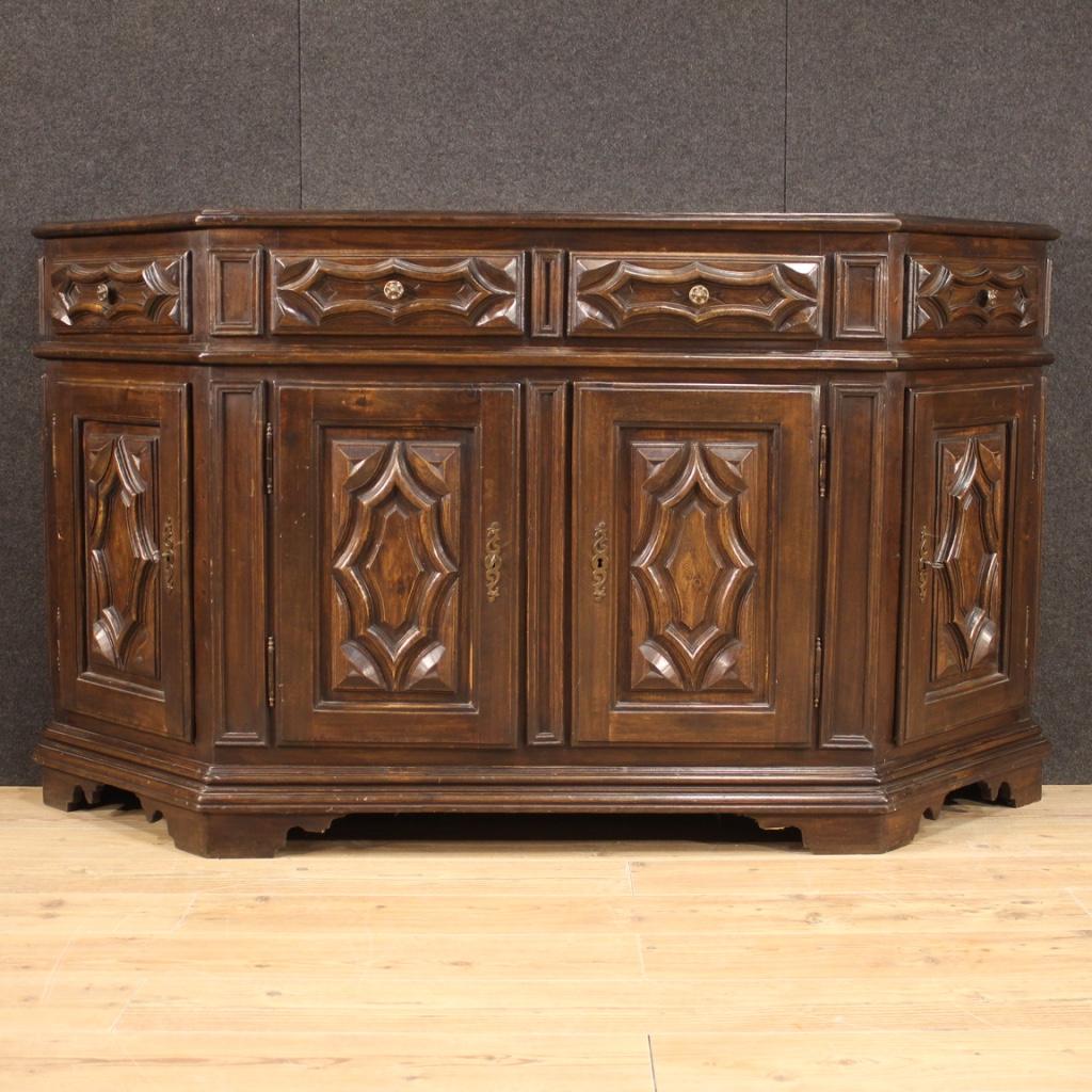 Italian sideboard from the mid-20th century. Notched furniture carved in oak and beechwood (there are plywood elements, backrest, top, drawer bottoms) in Baroque style of beautiful line and pleasant decor. Sideboard equipped with 4 doors and two