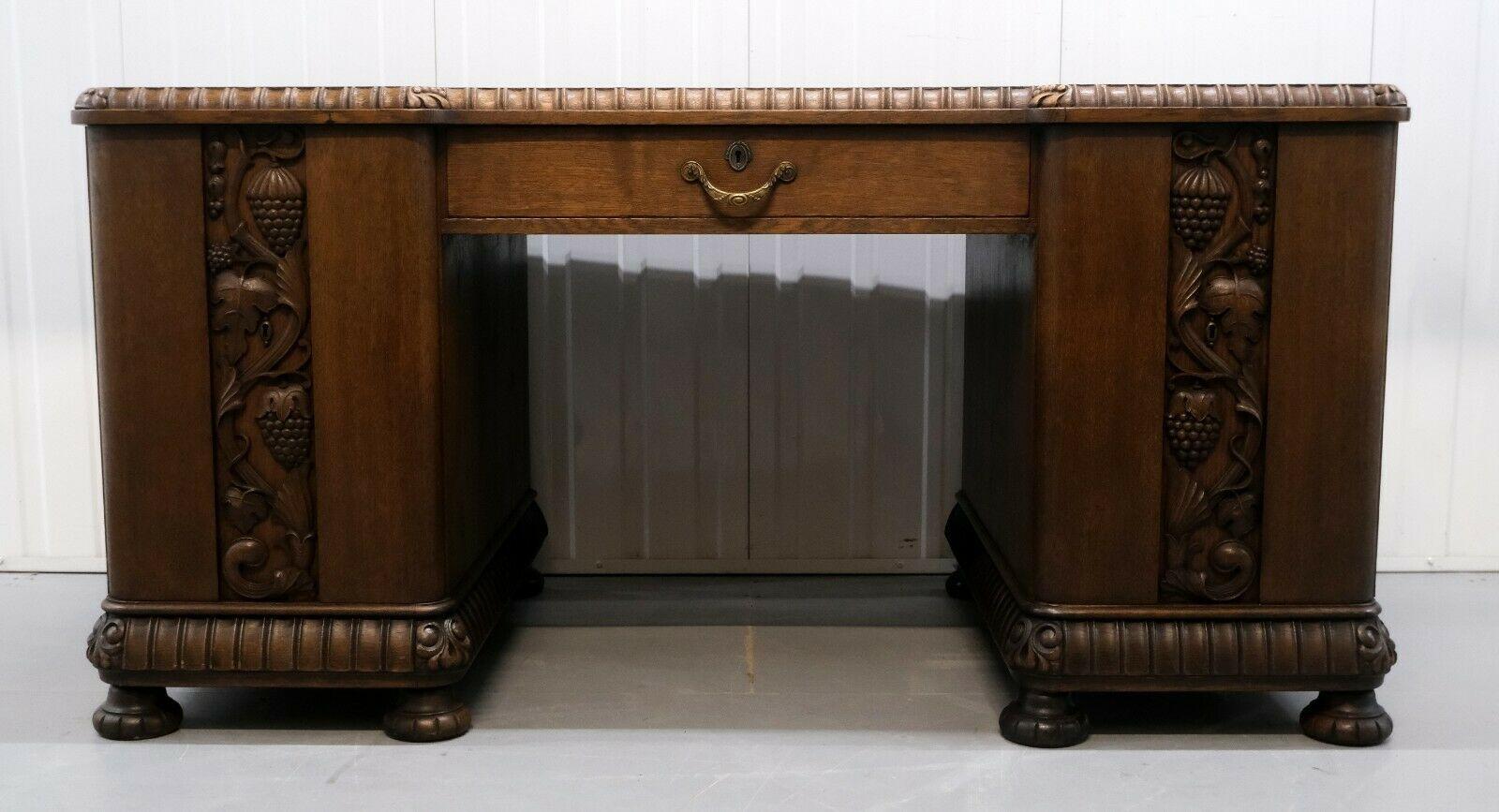 We are delighted to offer for sale this stunning very solid and heavy, early 20th century carved oak desk in one piece.

The practical desk is well decorated with vine leaves and grapes on the front doors. The rich brown colour and detailing