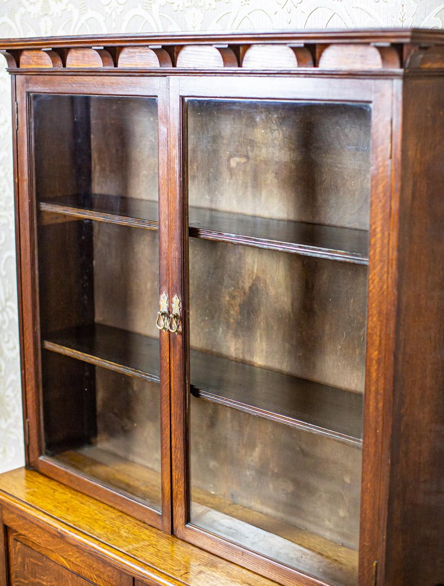 We present you this simple oak piece of furniture which can be used in various ways, such as a display cabinet, sideboard, or even a bookcase. It was manufactured before 1939.
The display cabinet-bookcase is composed of a two-leaf base and an