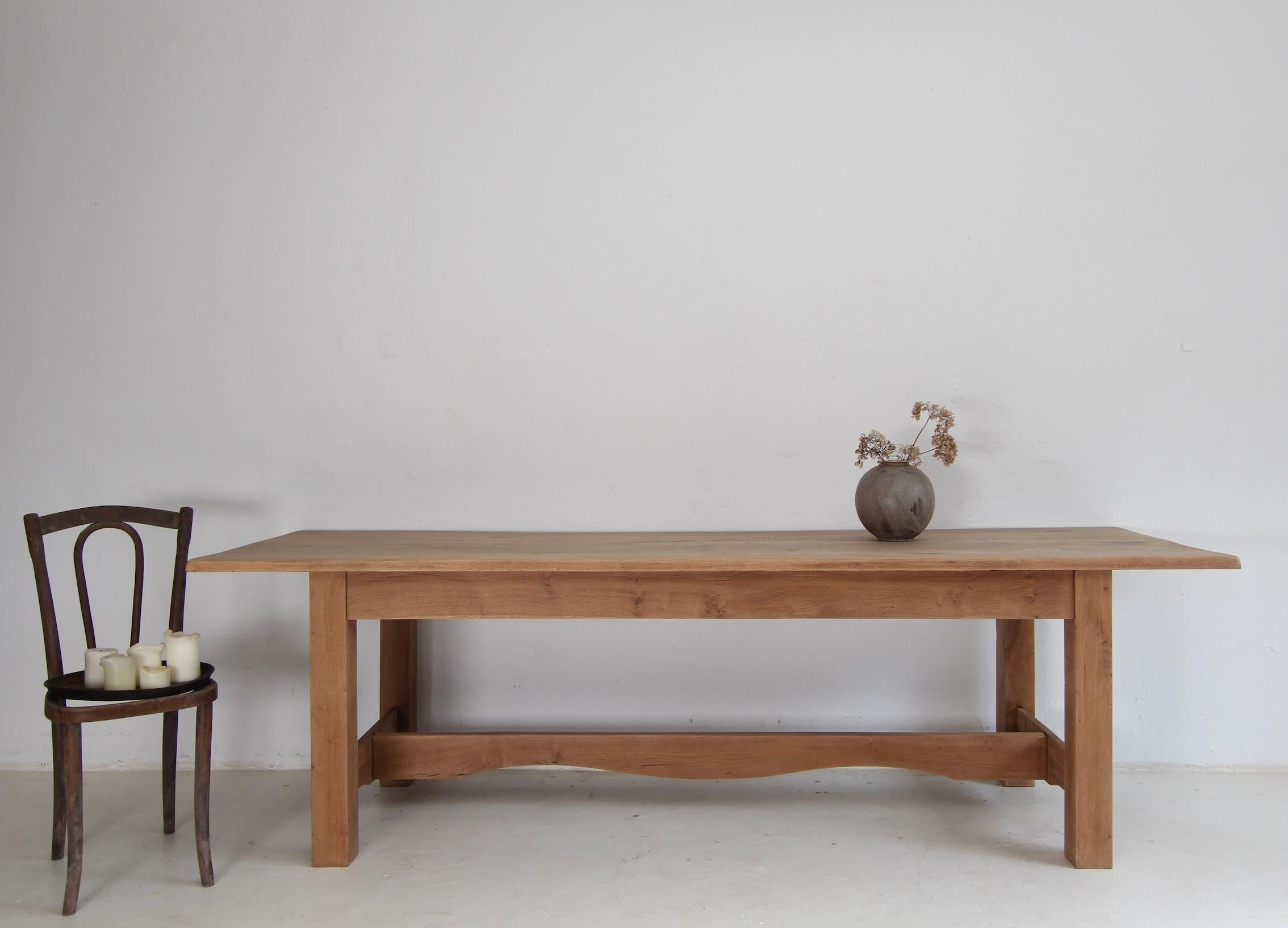 A wonderful simple country house dining table from the 20th century. Made of solid oak wood. Ideal for 8-10 people.

Table frame on a rectangular base, consisting of 4 square legs connected by an H-brace and frame with a top that protrudes