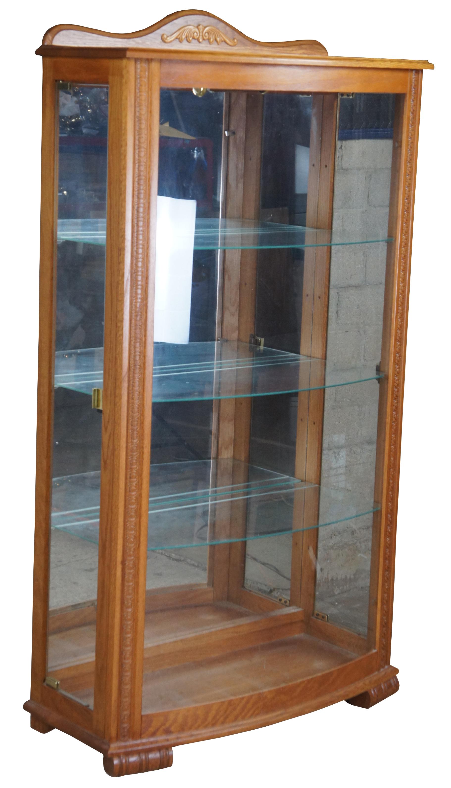 Vintage oak curiosity cabinet. Features three adjustable shelves illumnated from above with access for loading from both sides. Measure: 60