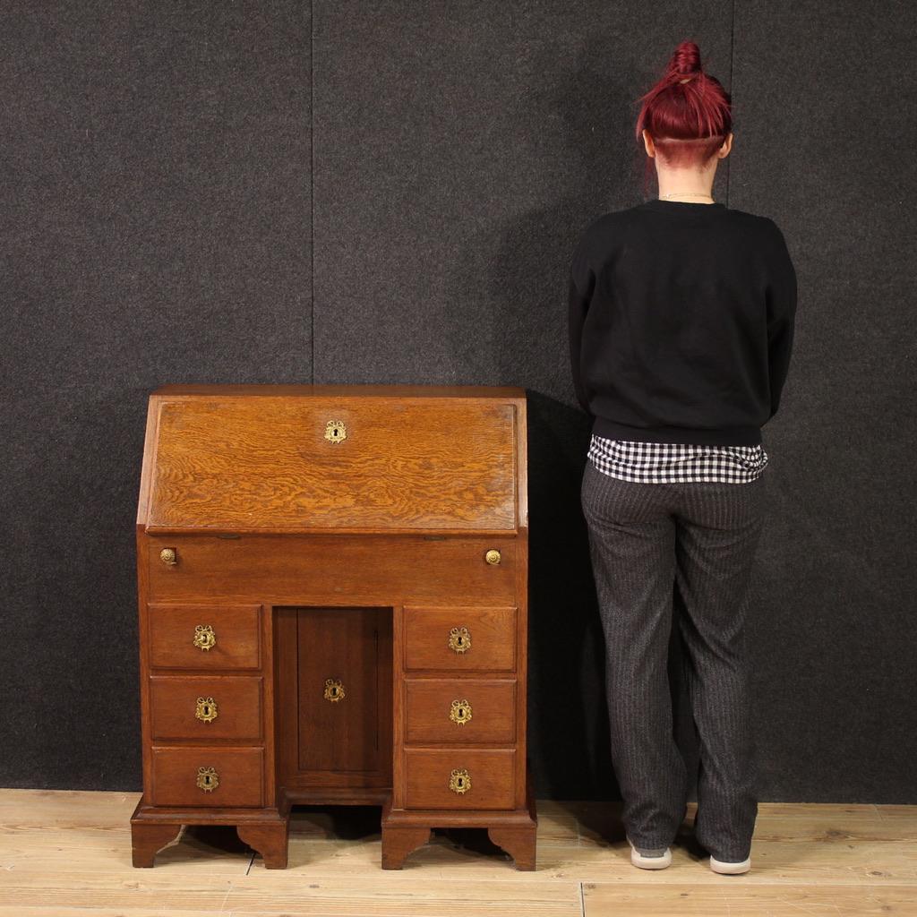 Dutch bureau from the first half of the 20th century. Furniture carved in oak of beautiful lines and excellent proportions. Bureau equipped with six external drawers and a central door, of good capacity. Fall-front that offers inside eight small
