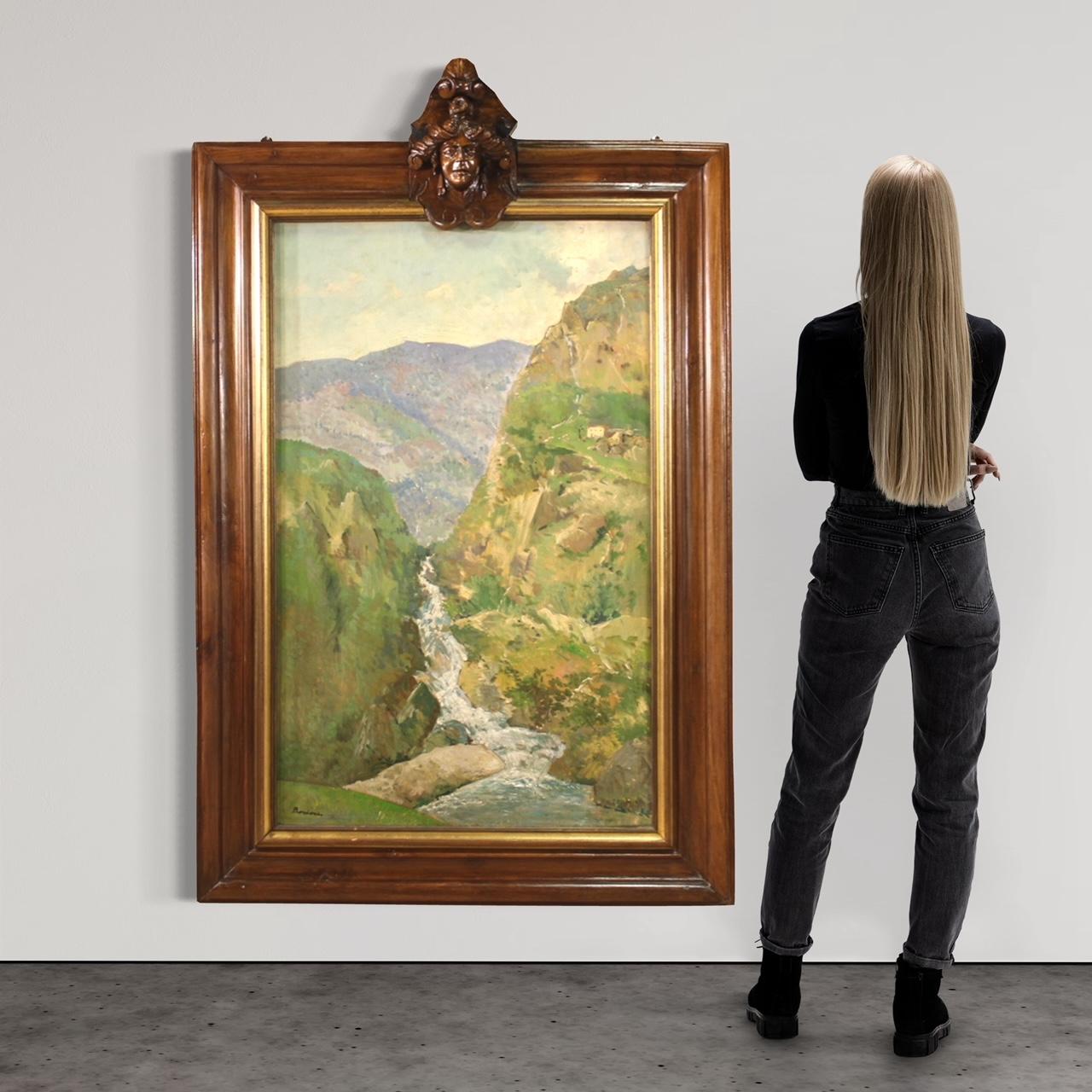 Grande peinture italienne du milieu du 20e siècle. Huile sur carton représentant un paysage de montagne avec une rivière et des maisons de style impressionniste. Tableau de taille exceptionnelle orné d'un cadre en bois avec masque supérieur et