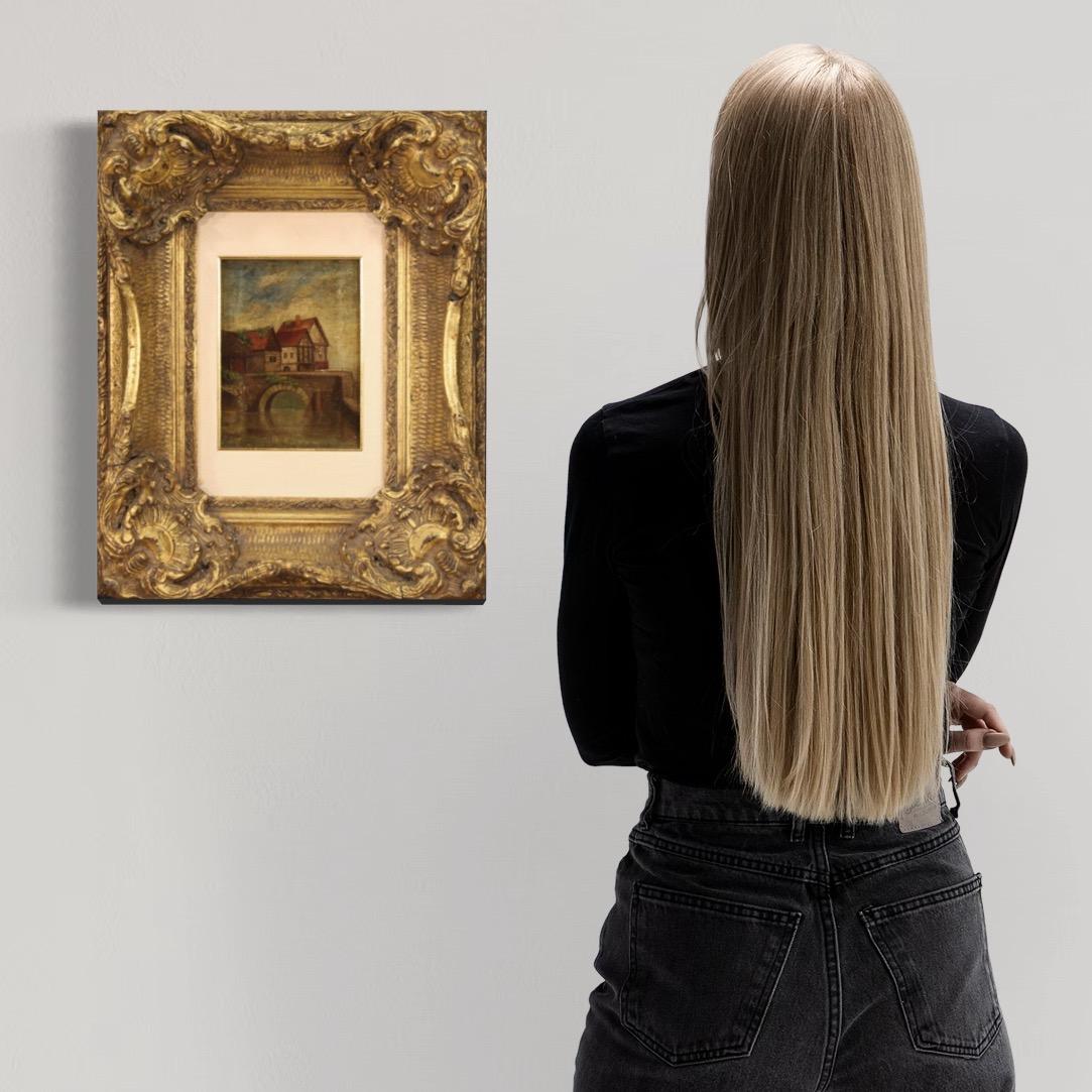 Small English painting from the first half of the 20th century. Framework oil on canvas depicting a landscape on the river with houses and a bridge of rustic character. Modern frame in wood and composite material richly chiseled, gilded and adorned