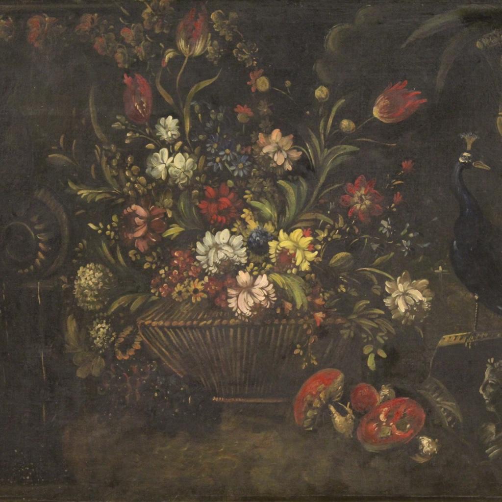 Large Italian painting from the first half of the 20th century. Framework oil on canvas depicting rich still life Vase with flowers, fruit, peacock and sculptures / decorations in neoclassic style. Frame in wood and plaster, carved and gilded
