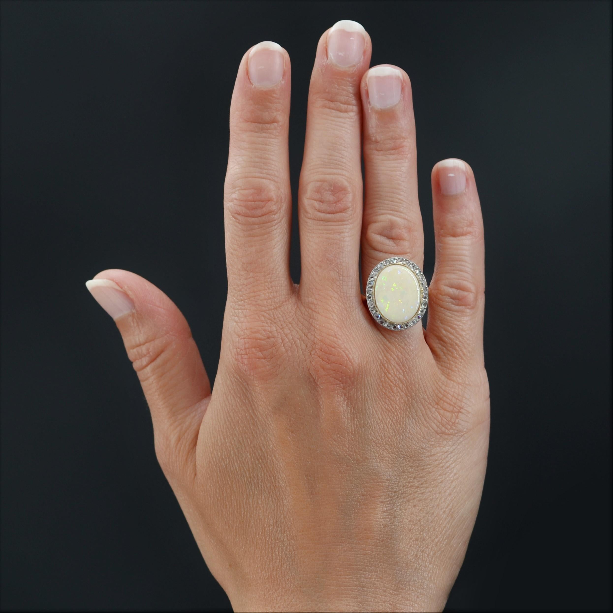 Ring in 18 karat yellow gold.
Presenting a flat and openwork setting at the level of its basket this magnificent antique ring is decorated, in closed setting millegrain, of an Australian noble opal, in a surrounding of rose- cut diamonds.
Weight of