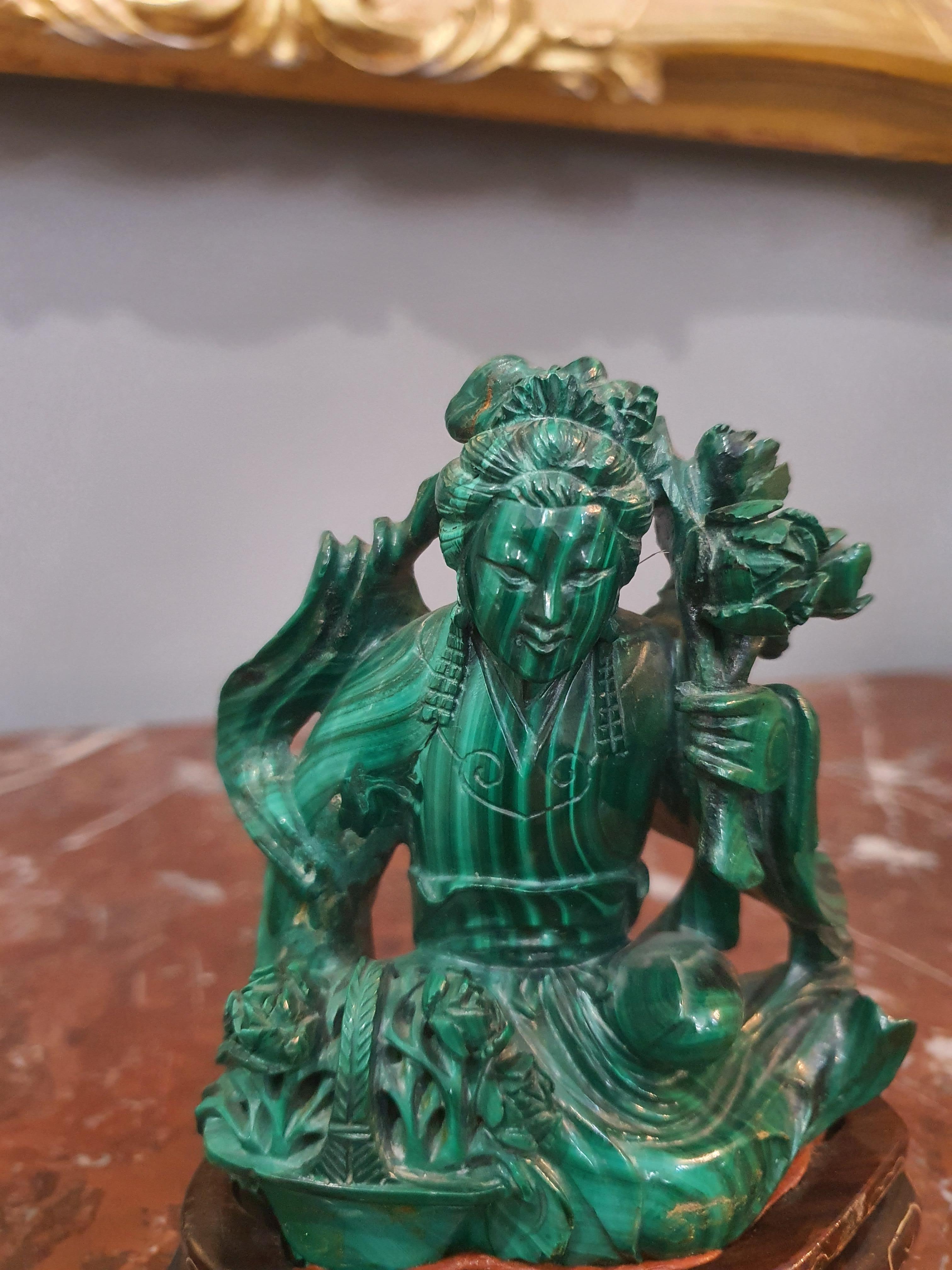 Valuable sculpture depicting an oriental figure. Made from a single block of flowery malachite. Mounted on a carved wooden base.