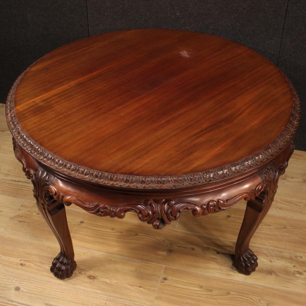 Chinese living room coffee table from 20th century. Furniture in exotic wood richly carved and chiseled of beautiful lines and pleasant decor. Round table with top of excellent size and service, supported by four solid legs finished with zoomorphic