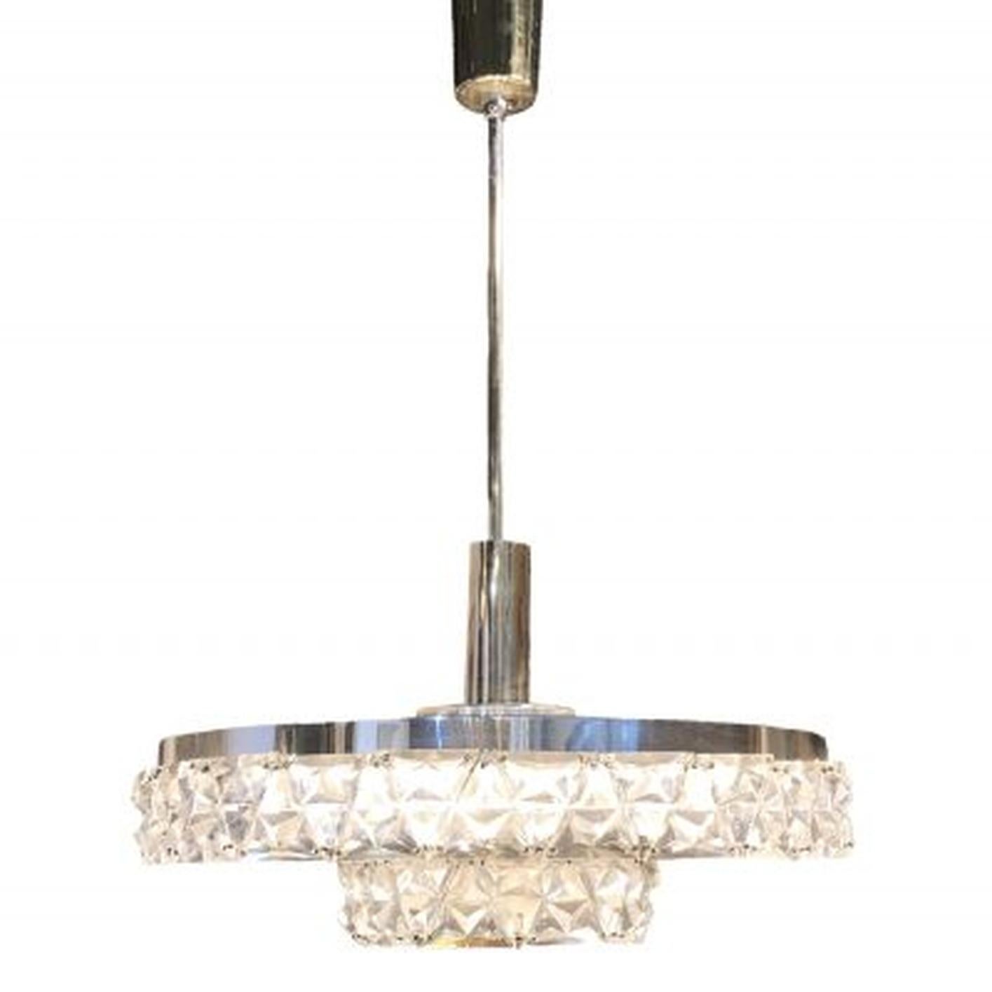 A round, vintage Mid-Century Modern Swedish ceiling light, lamp made of a chrome, brass frame and hand blown Orrefors glass, featuring a four light socket. The Scandinavian chandelier, pendant was designed by Carl Fagerlund and produced by Orrefors