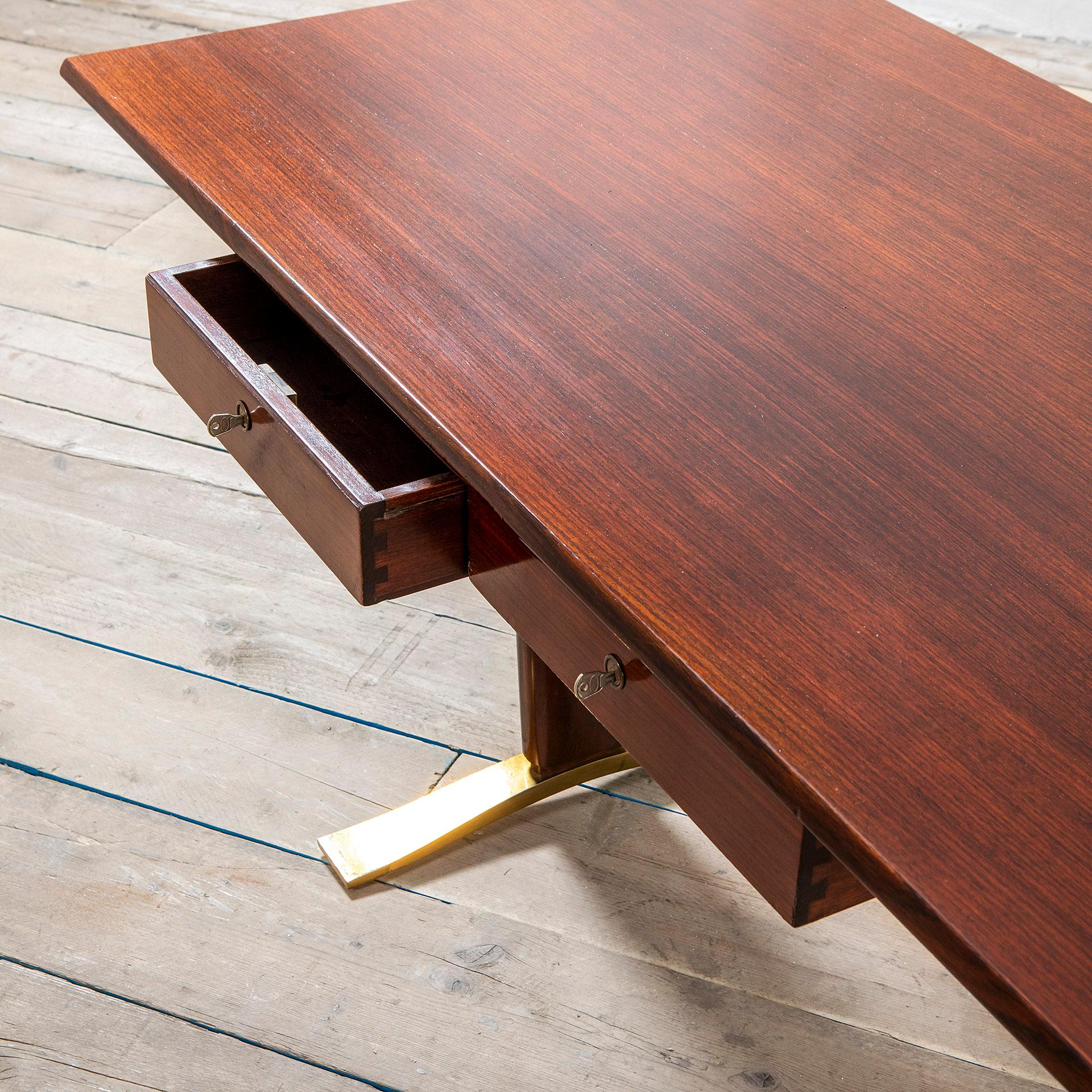 Desk designed by the italian Maestro Osvaldo Borsani in half sixties. The desk has a very modern line, the top is very thin and has two drawers that seems suspended, each drawer has its own original key. The table stands with two peculiar feet made