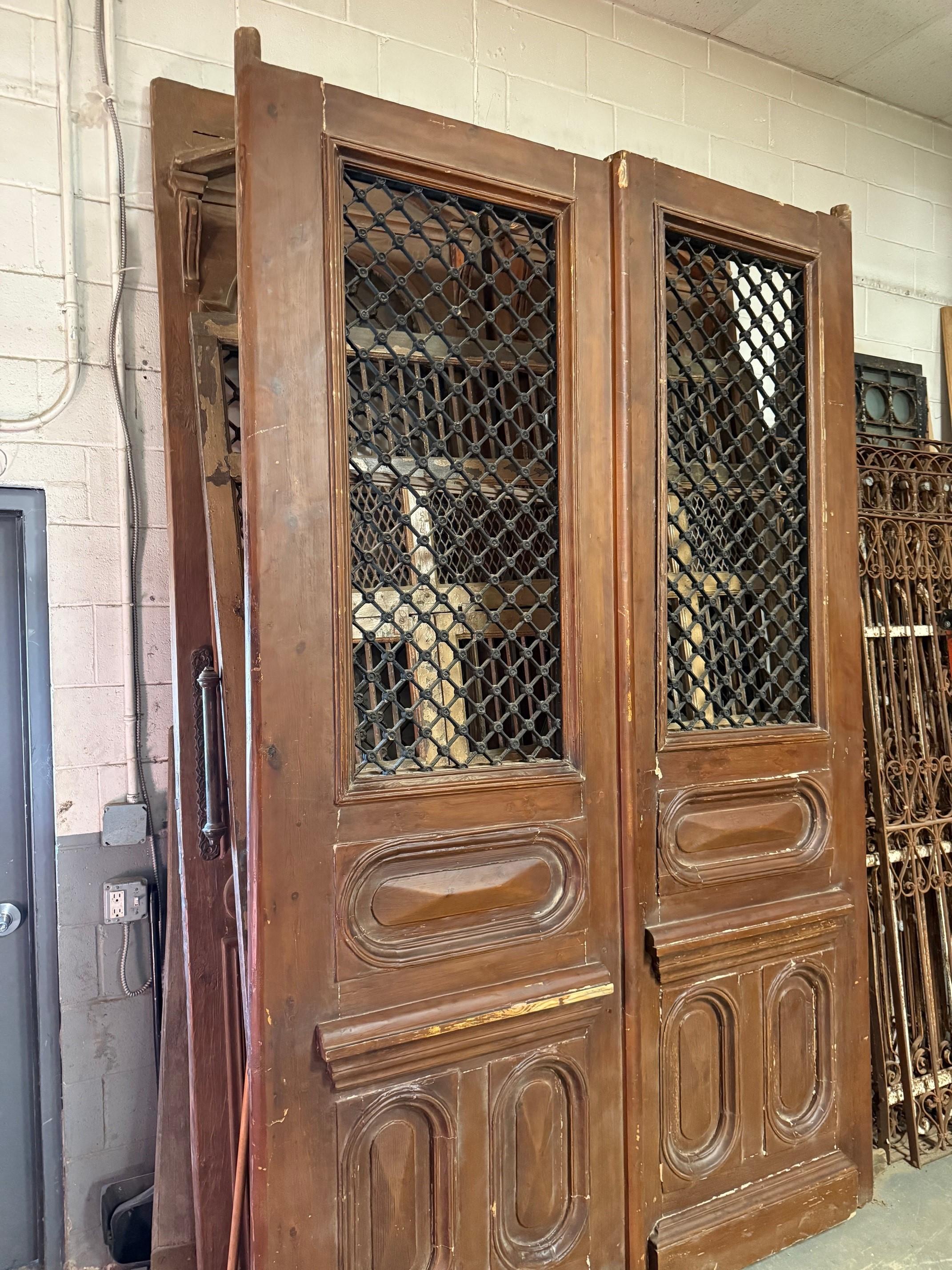 Early 20th Century oversize pair of Egyptian doors with Iron and wood panels. This pair of Egyptian doors were produced at a time when French architecture and style had a great influence on the Egyptian culture, especially in Cairo. They are a very
