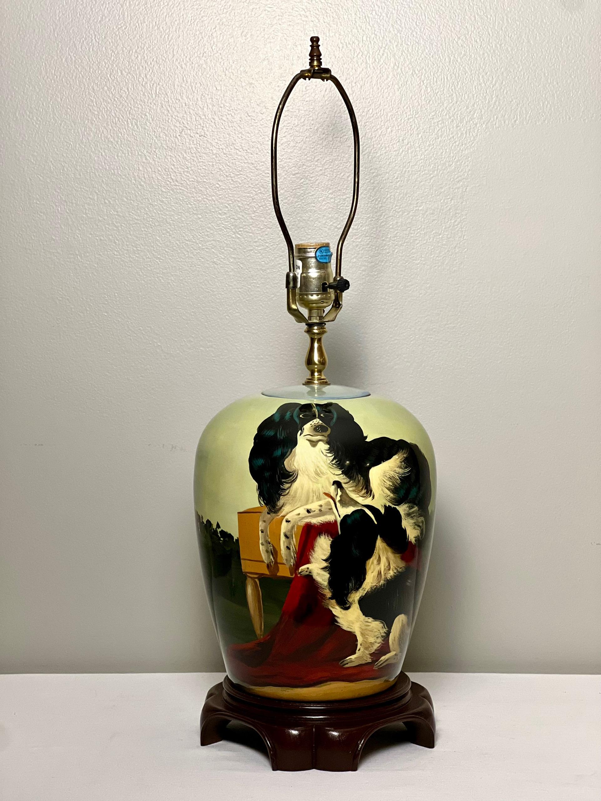 Lámpara ovoide de cerámica pintada a mano con perros sobre una base de madera oscura, de Jene's Collection Design Studio, finales del siglo XX. Lámpara de acabado brillante y vibrantemente pintada que representa una escena de dos cocker spaniel