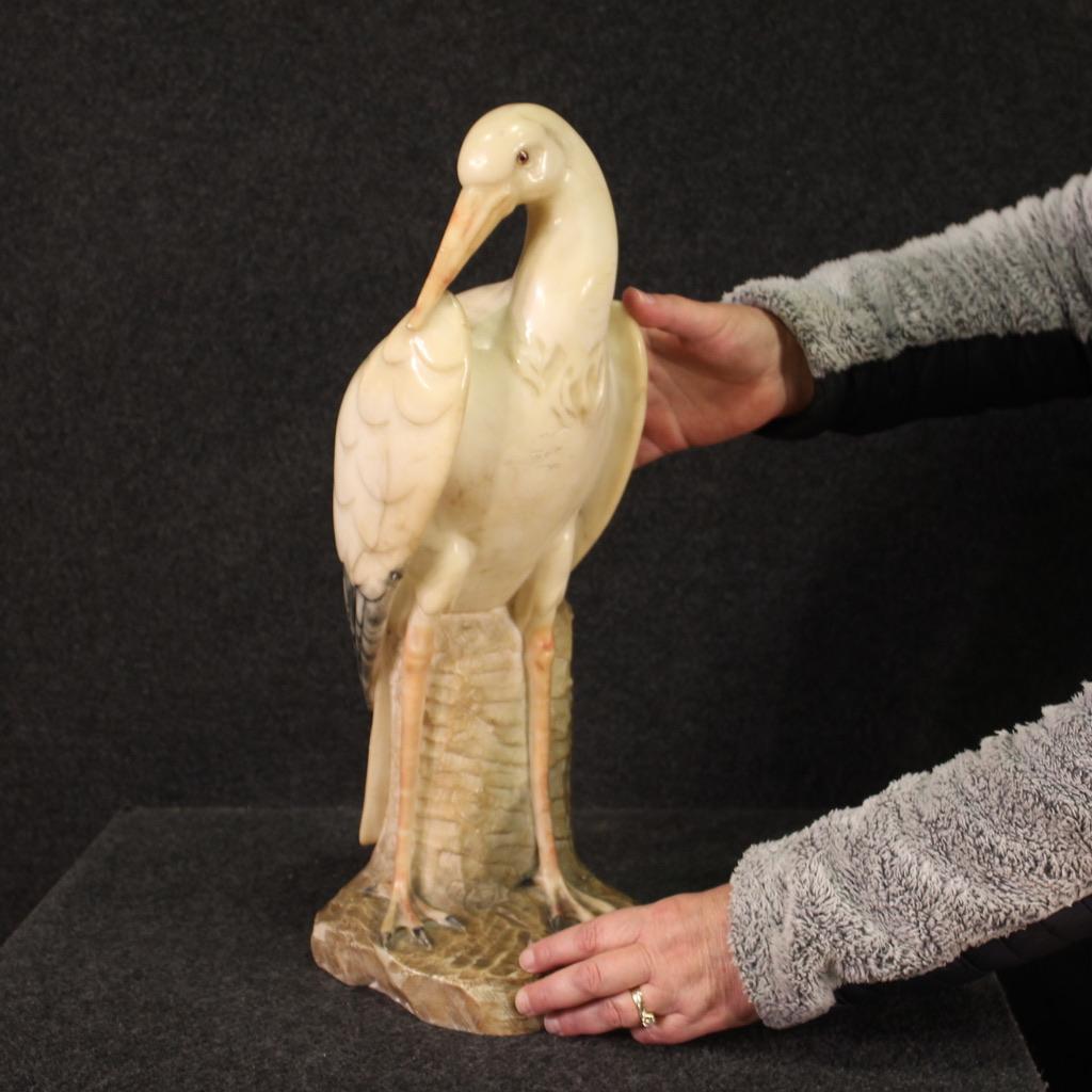 Sculpture italienne du milieu du 20e siècle. Objet en albâtre agréablement ciselé et patiné représentant un élégant héron avec des yeux en verre peint. Travail pour les antiquaires et les collectionneurs, fini au centre, avec un poids considérable