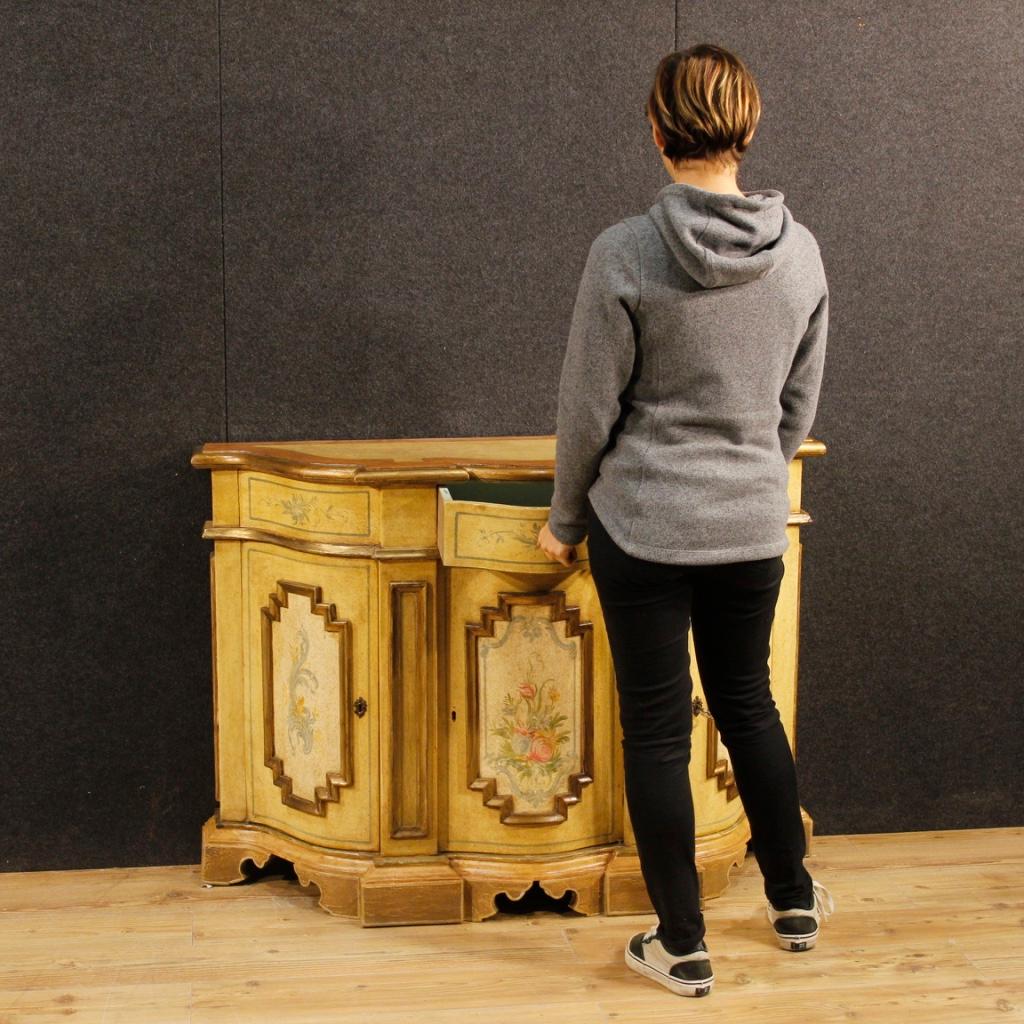 Italian sideboard from 20th century. Pleasantly carved, gilded and hand-painted wooden furniture with floral decorations. Sideboard with three doors and a drawer complete with a working key, of good capacity and service. Wooden top in character with