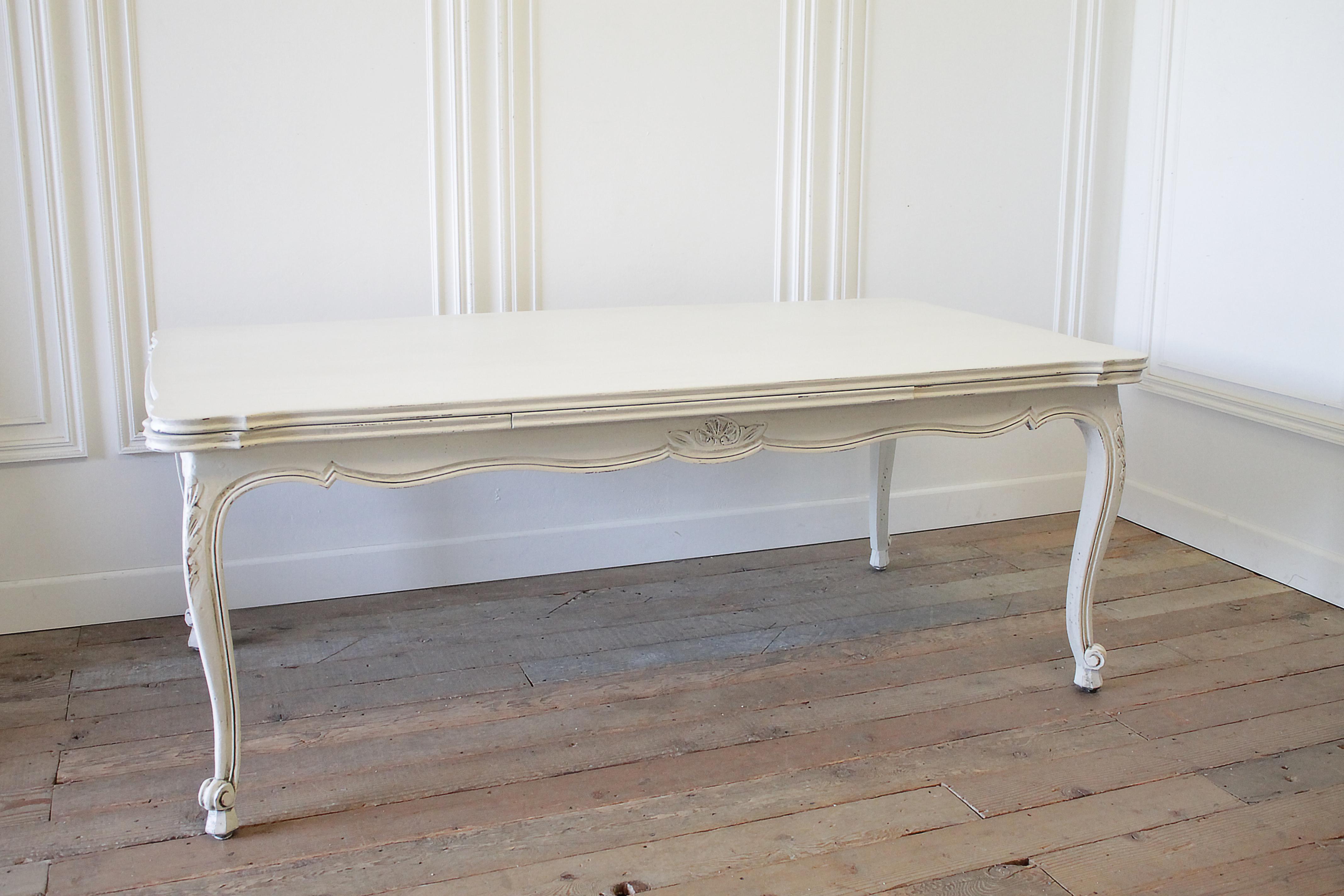 Good quality French farmhouse extending table can seat up to 12. Slight serpentine outer edge, carved frieze and knees. Painted in a off-white with subtle distressed edges, and waxed finish. 
Measures: 78.5