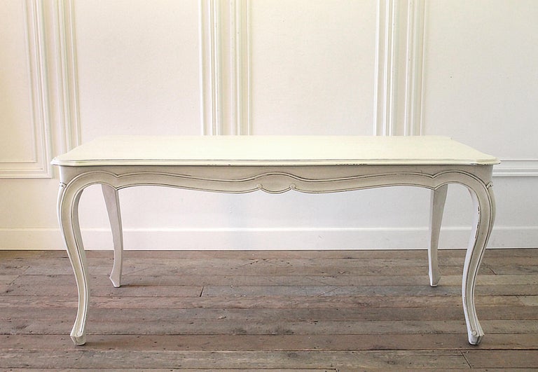 20th century painted Louis XV style country French dining table with drawers
painted in a soft white finish, with subtle distressed edges, and antique glazed patina.
Storage drawers are at each end of the dining table. Lets are solid and sturdy,