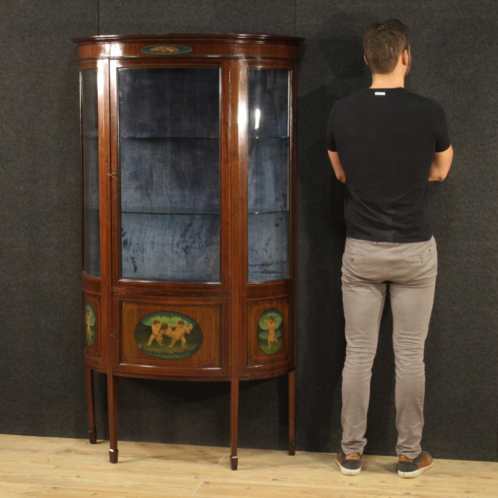 English showcase from the mid-20th century. Furniture in carved, painted and threaded wood in mahogany and maple. Demilune display cabinet built in a single non-divisible block and supported by 4 solid legs also inlaid (see photo). Bookcase adorned