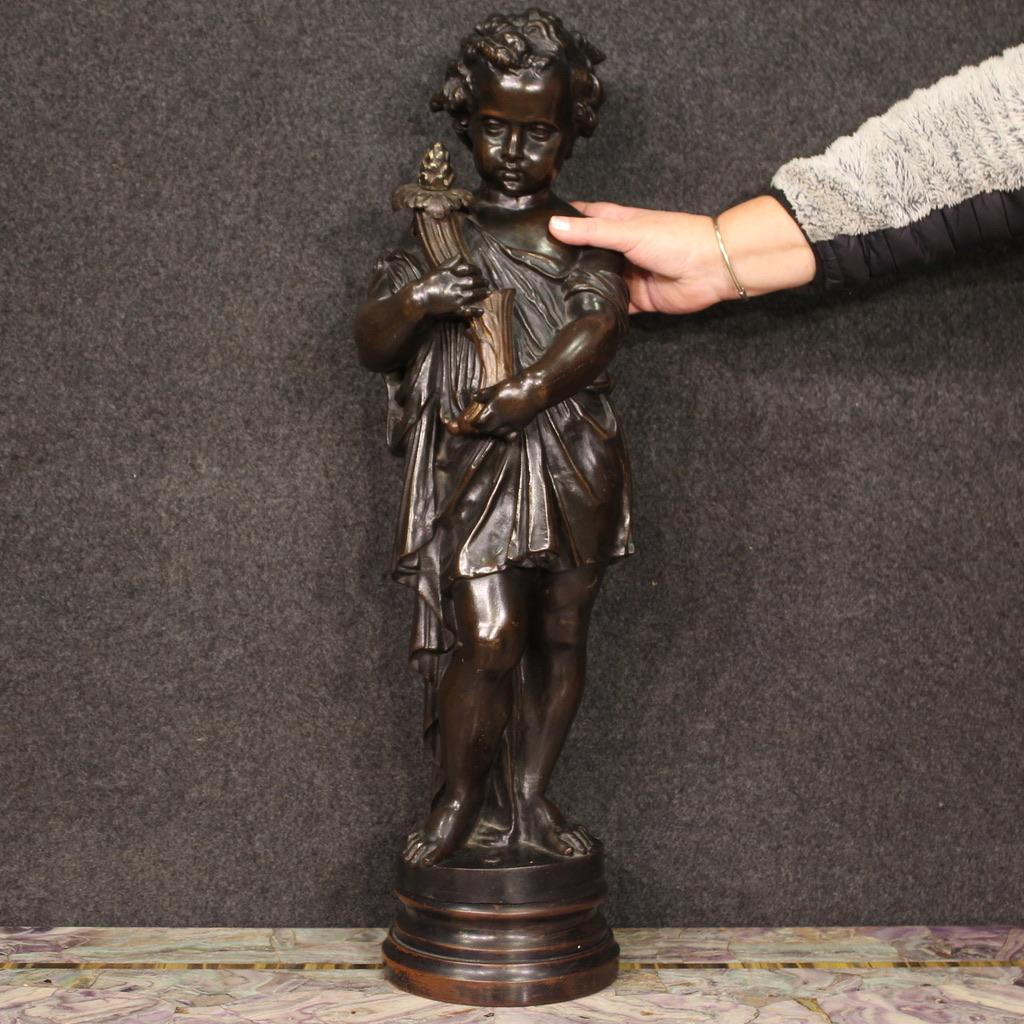 Sculpture française de la première moitié du 20e siècle. Œuvre en métal patiné, couleur bronze, montée sur une base en bois représentant un chérubin avec une corne d'abondance, de belle décoration et qualité. Sculpture terminée par le centre, de