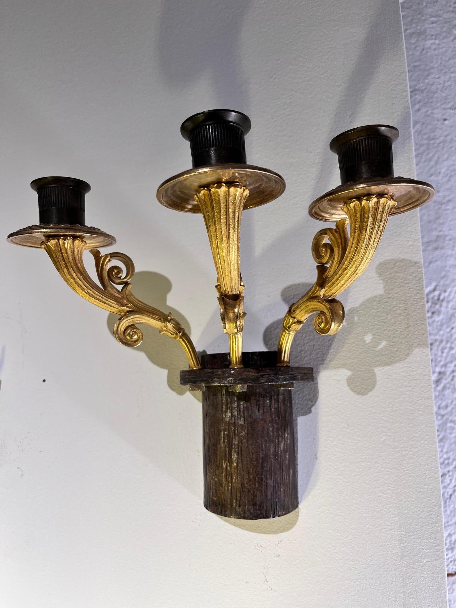 Elegante pareja de apliques de pared franceses de bronce dorado fabricados totalmente en metal, incluidas las placas traseras, que presentan un acabado patinado oscuro diseñado para asemejarse a la madera tallada.
Cada candelabro presenta tres