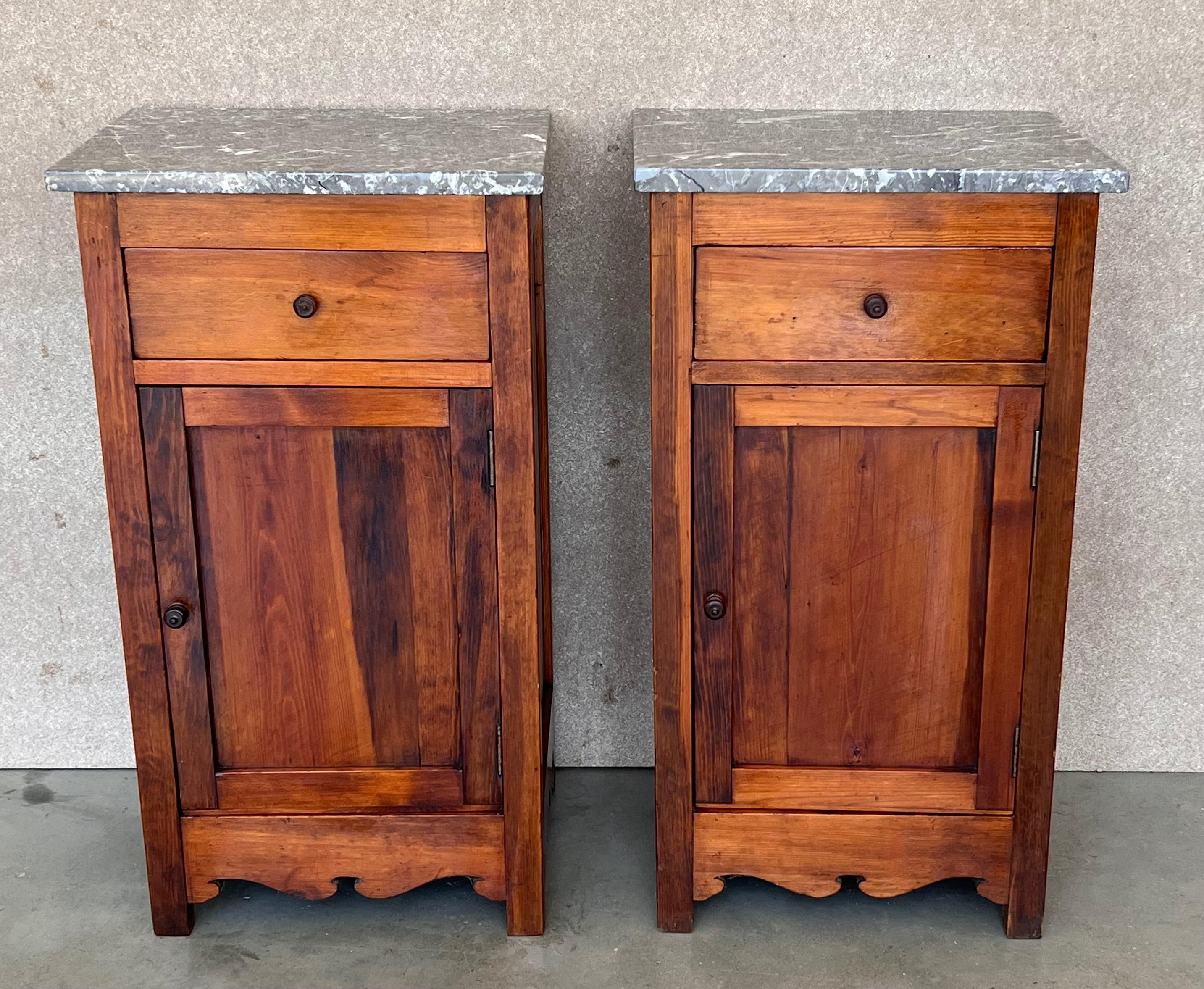 Pair of antique Biedermeier style bedside cabinets, late 19th-early 20th century, possibly French or Spanish, each in oblong rectangular form, the marble atop a fabric-lined surface, over a conforming case fitted with a single drawer over a cabinet