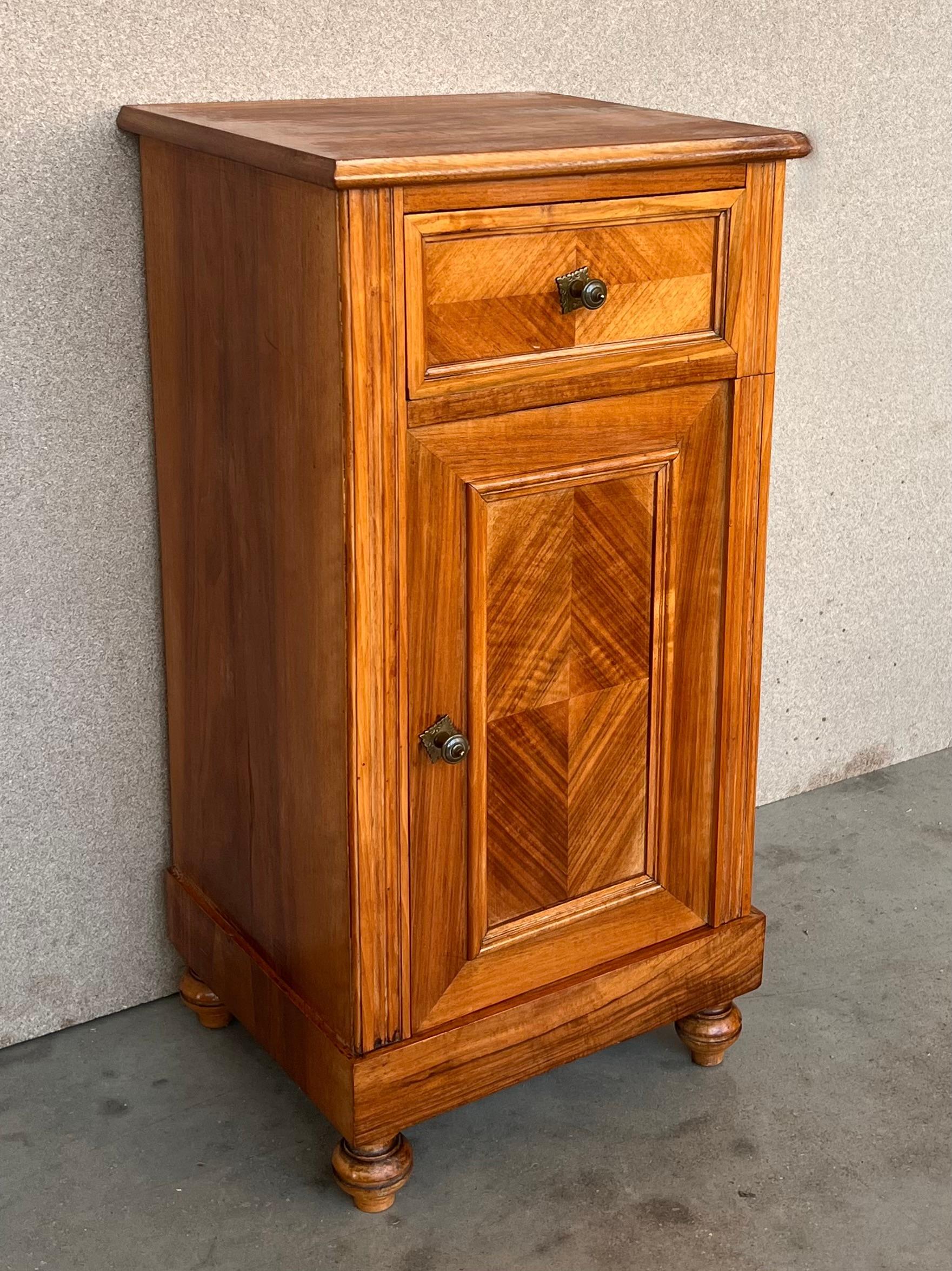 Pair of antique Biedermeier style bedside cabinets, late 19th-early 20th century, possibly French or Spanish, each in oblong rectangular form, wood top over a conforming case fitted with a single drawer over a cabinet door, raised on block base with