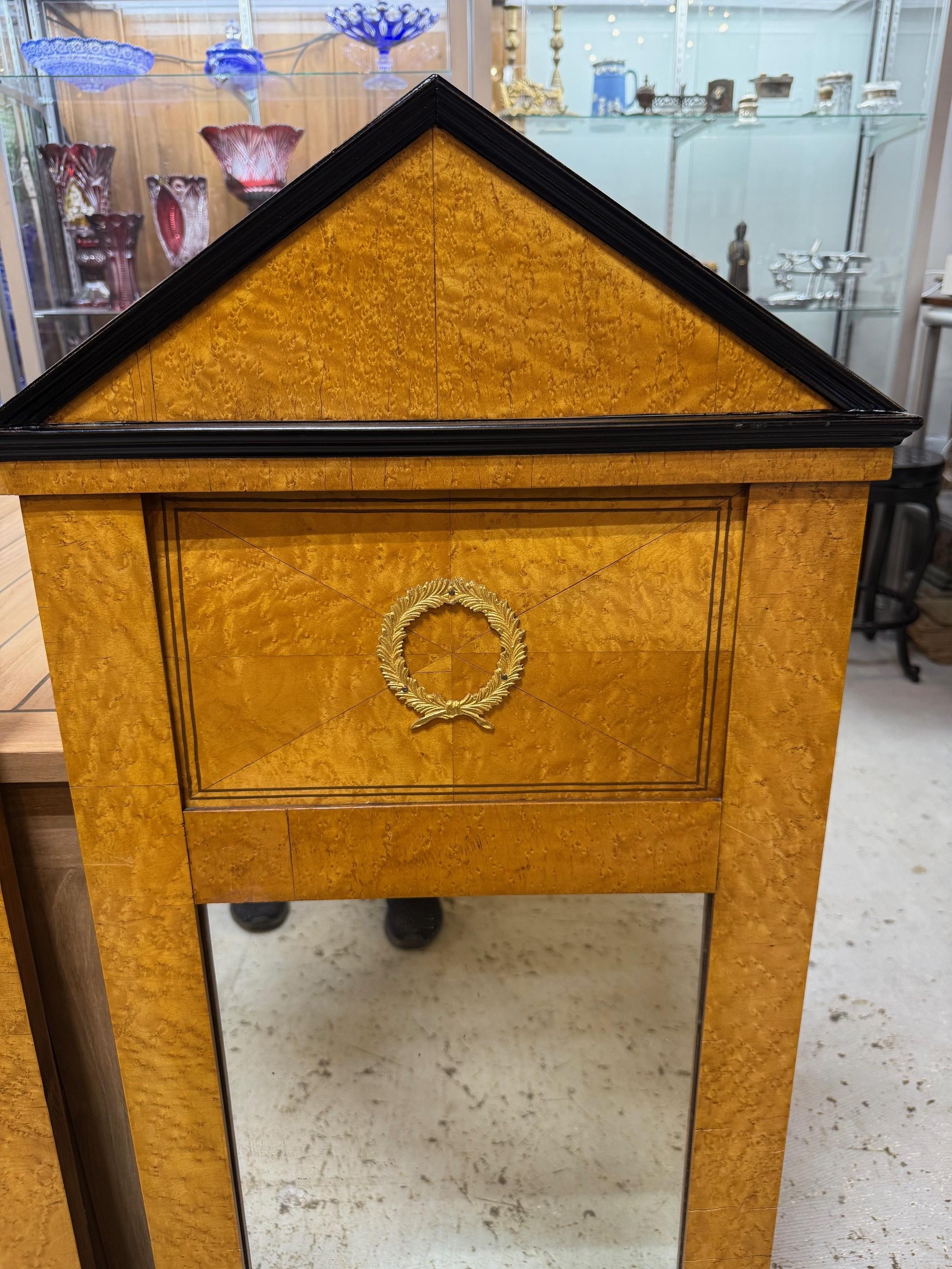 Bellissima coppia di specchi in stile Biedermeier della metà del XX secolo con impiallacciatura in radica e corona di alloro. Il periodo Biedermeier, che va all'incirca dal 1815 al 1848, era caratterizzato da uno stile che enfatizzava il comfort, la