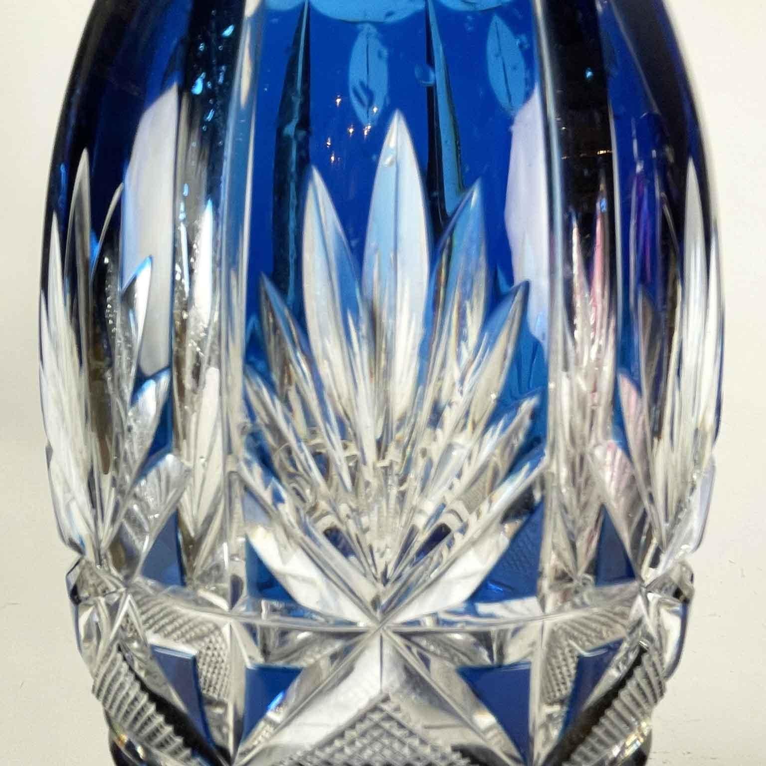 Pair of red a blue crystal liquor bottles, with a pear-shaped shape with grinding of geometric engravings on the base and on the body giving a beautiful shine. Silver neck marked with the title of 800/000 and the silversmith's mark.  The pinnacle