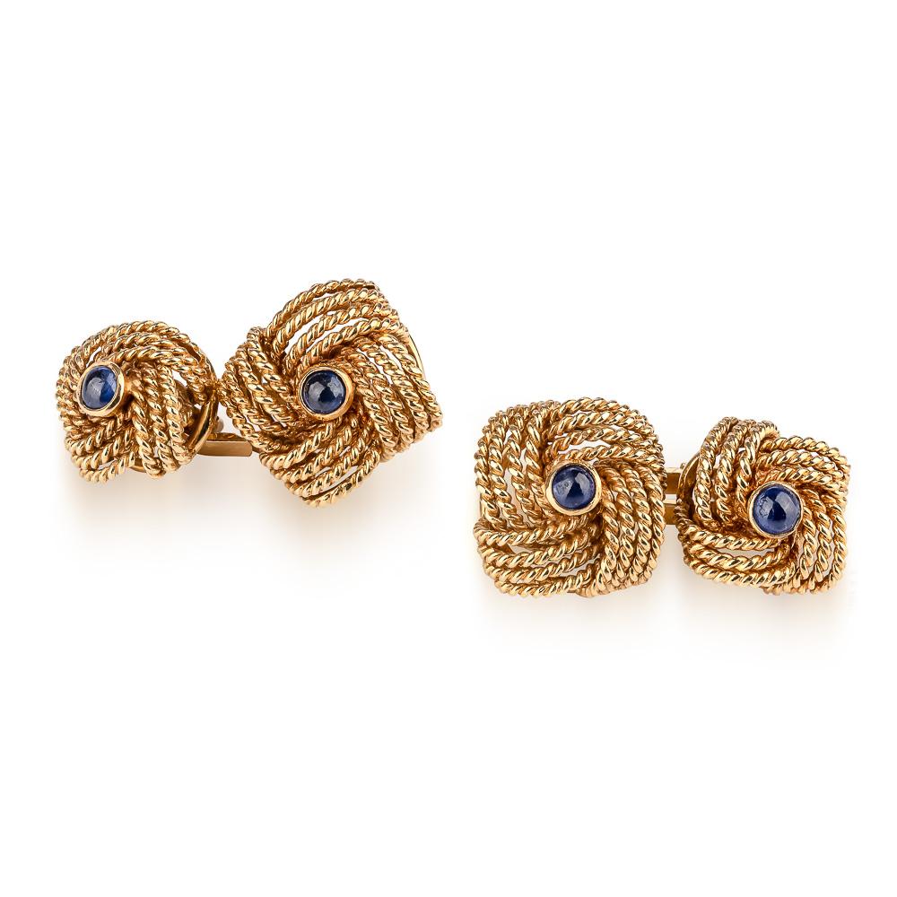 Un elegante par de gemelos de oro de 18 quilates y zafiro. Diseñado en forma de corona / botón entrelazado con un pequeño cabuchón de zafiro en cada pieza. Vendido por Harrods y perfectamente presentado en la caja original de Harrods London SW.

Oro