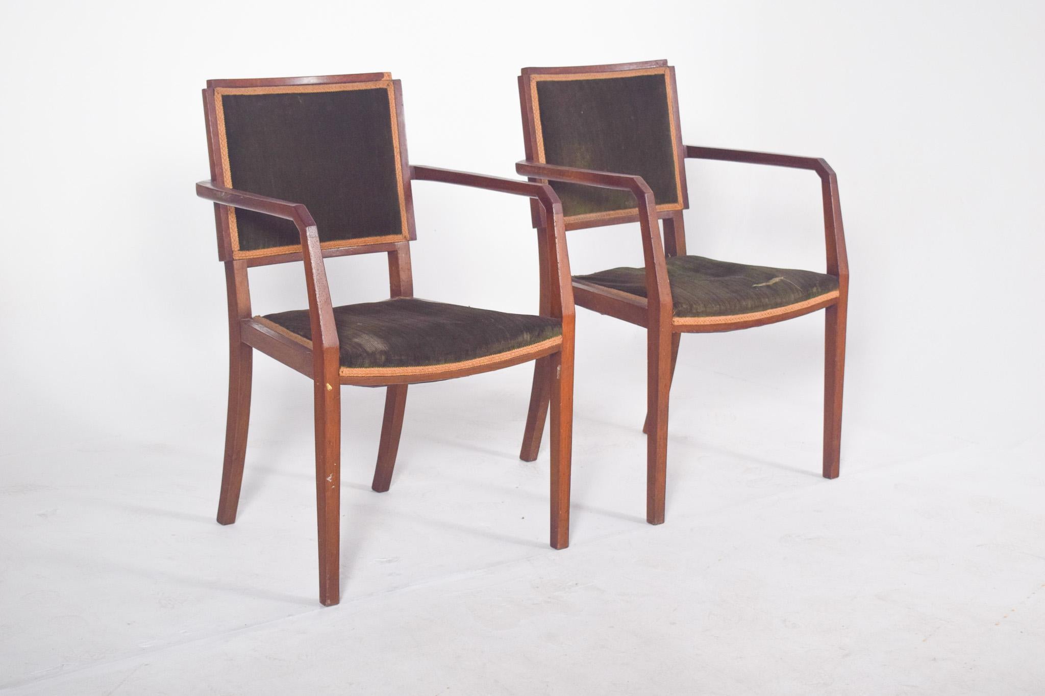 Pareja de sillas con reposabrazos, tapizadas en verde. De diseño modernista, posiblemente de la década de 1940, tienen un marco de madera maciza con líneas rectas y esquinas ligeramente redondeadas, típico de la estética funcionalista y racionalista