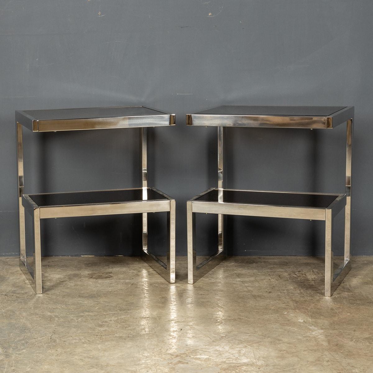 A pair of polished chrome G shaped end tables by Belgo Chrome with smoked glass top and mirrored shelf, c. 1970s. A wonderful addition to any interior, that will undoubtedly add style and sophistication.

Condition
In Good Condition - wear