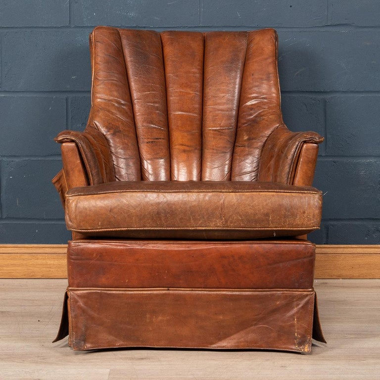 Showing superb patina and colour, this wonderful club chair was hand upholstered sheepskin leather in Holland by the finest craftsmen in the latter part of the 20th century. A very particular model being high backed with low armrests and a