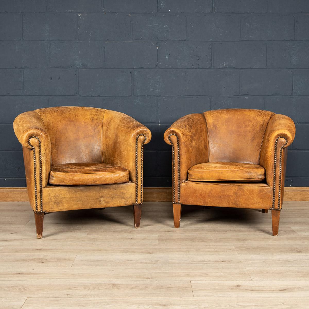 A wonderful pair of leather wing back armchairs. Dating to the latter part of the 20th century these chairs have been realised by the finest Dutch craftsmen, the solid wood frame upholstered in superb quality honey coloured sheepskin leather which