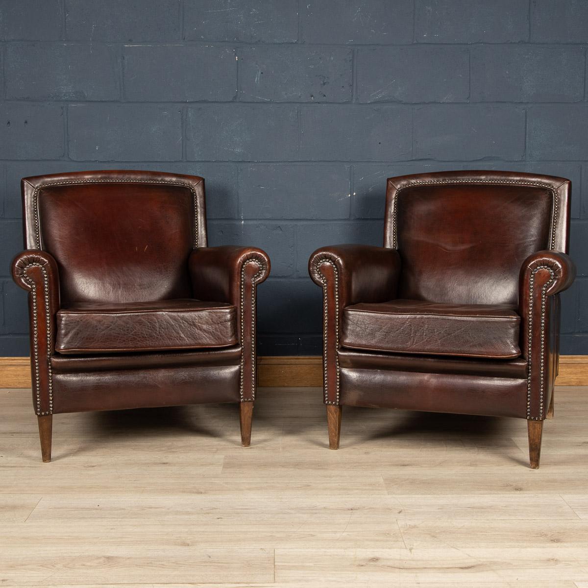 A wonderful pair of leather wing back armchairs. Dating to the latter part of the 20th century these chairs have been realised by the finest Dutch craftsmen, the solid wood frame upholstered in superb quality honey coloured sheepskin leather which