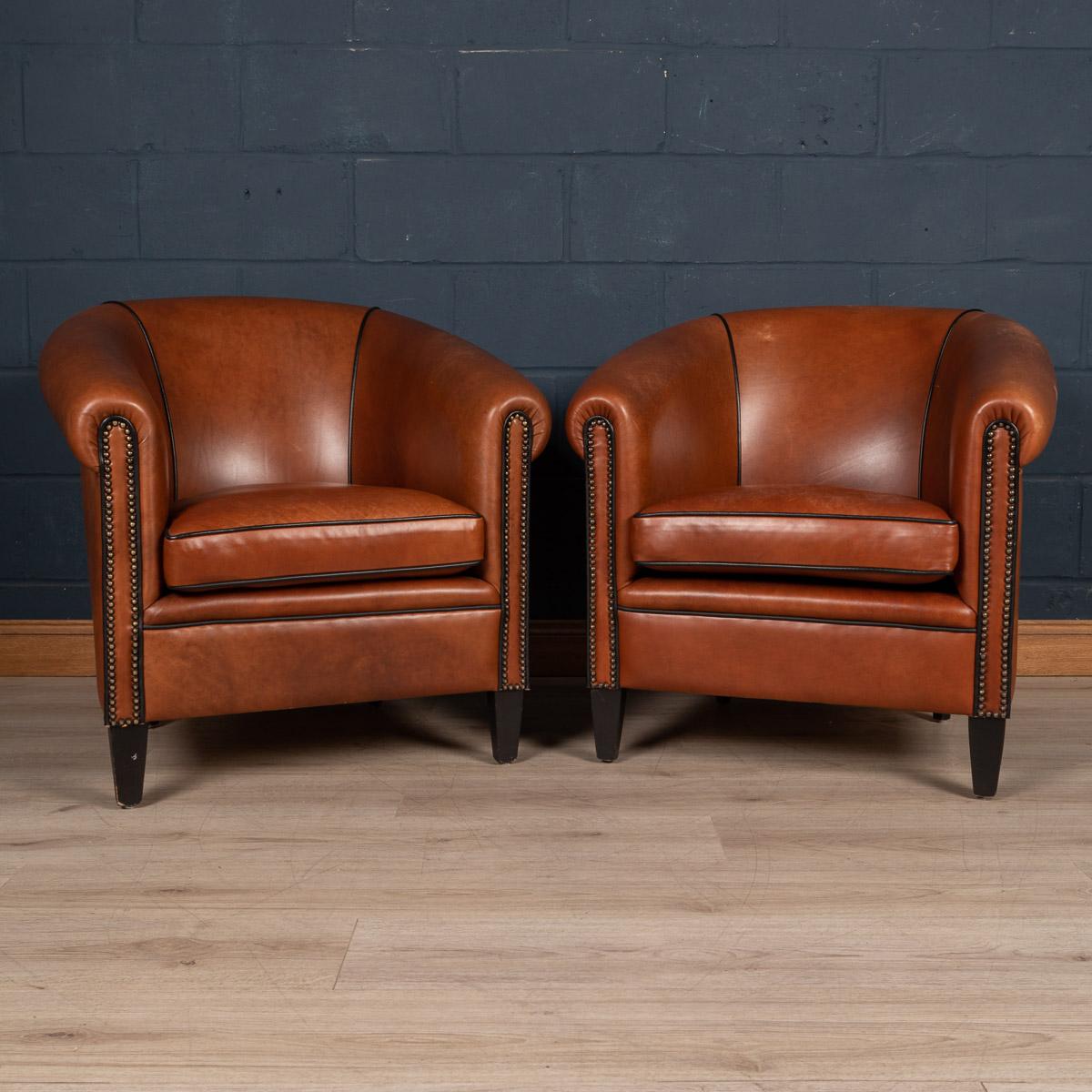 Showing superb patina and colour, this wonderful pair of club chairs were hand upholstered sheepskin leather in Holland by the finest craftsmen.

Condition
In good condition - wear consistent with age.

Size
Height: 80cm
Width: 75cm
Depth: