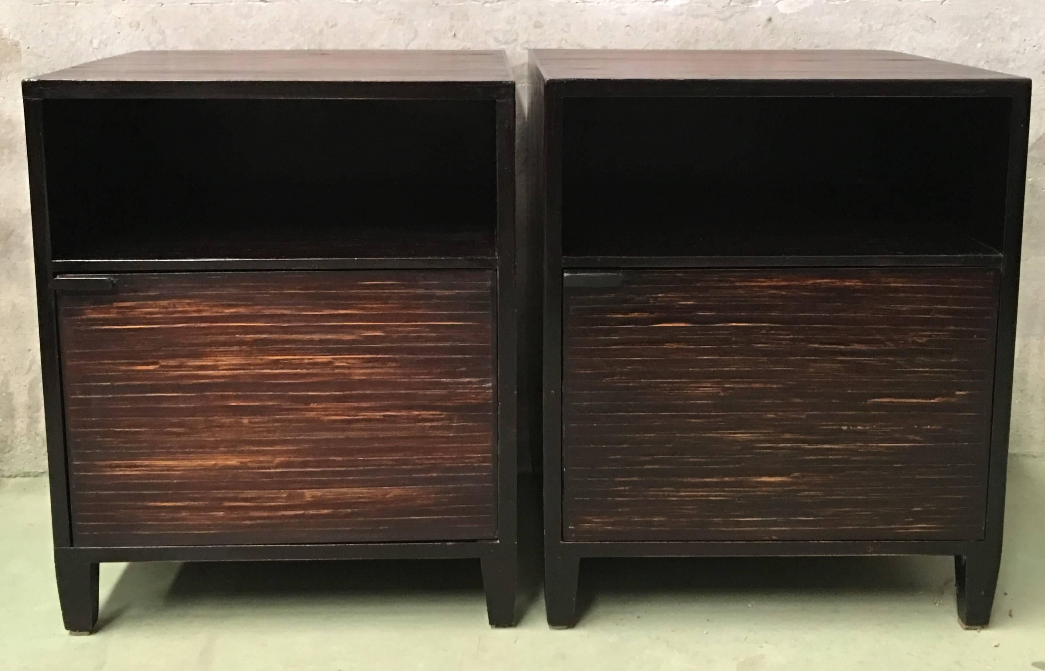 This very sophisticated nightstands or end tables feature a shadow box detailing framing the front. It features a cabinet with a shelf space above and also a cube with door. They are made of ebonized wood and have been restored to mint condition.