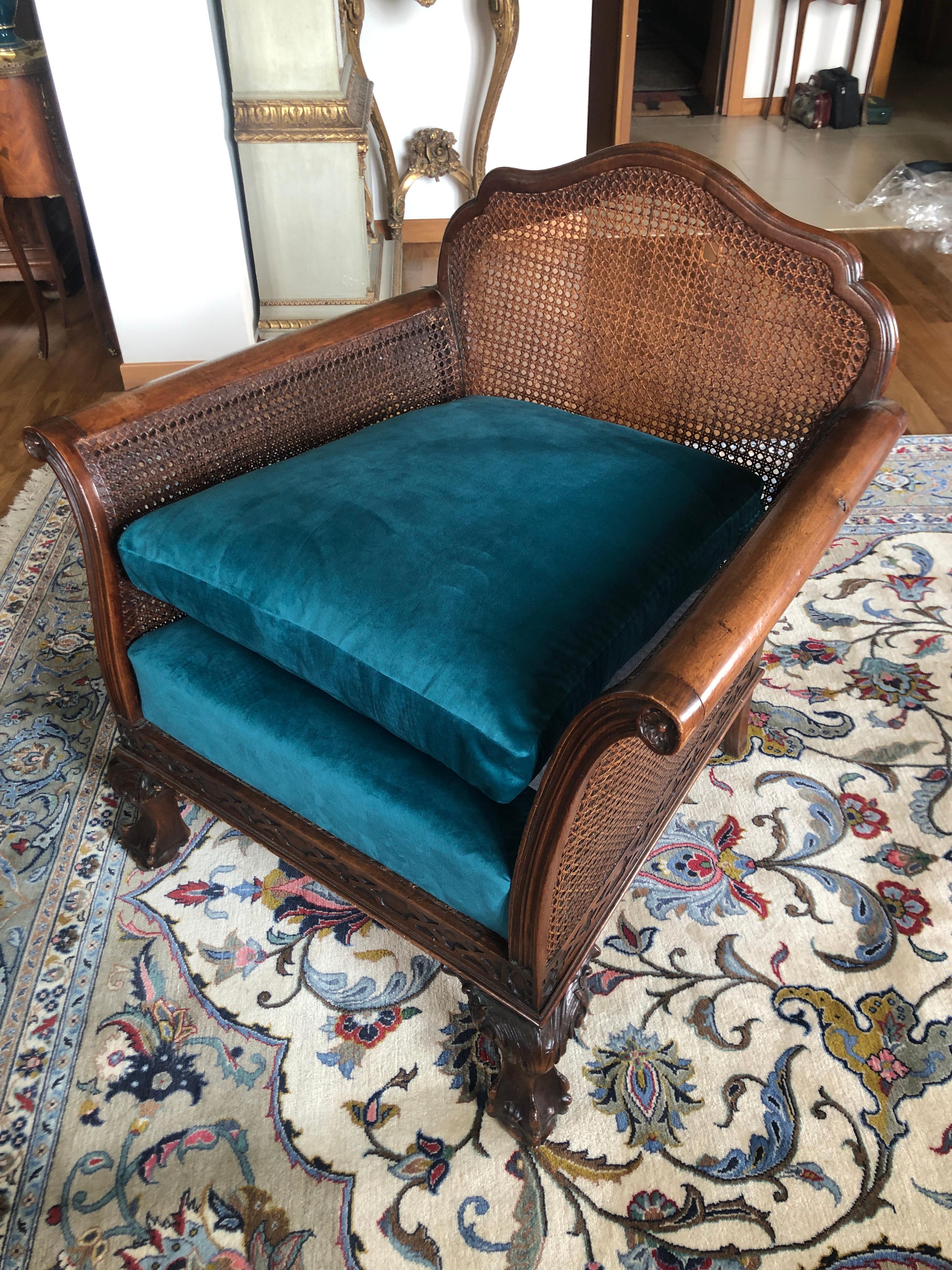 Pair of dark flame birch carved armchairs upholstered in blue. Features caned back and arms and exposed carved wood that has a handsomely aged patina.
France, circa 1920.