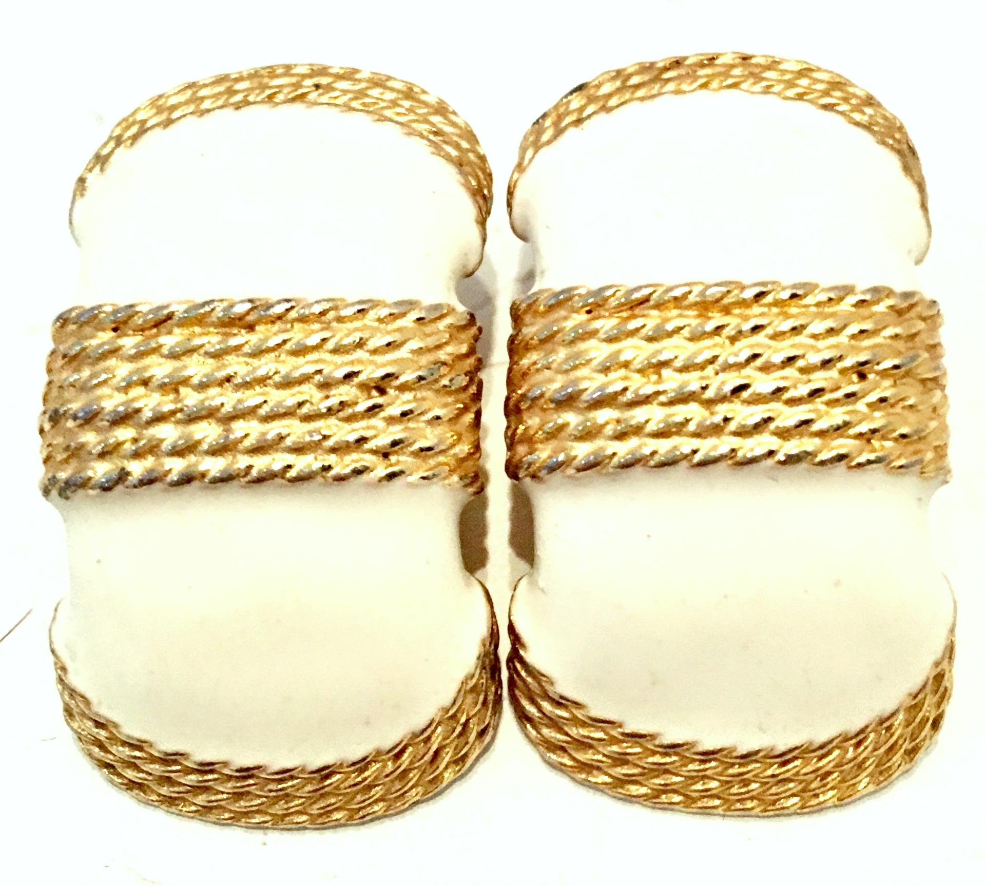 20th Century Pair Of Gold Plate & Enamel Earrings By, Gay Boyer. These crescent shaped gold clip style earrings feature off white enamel and gold overlay braid detail.
Signed on the underside, Gay Boyer.