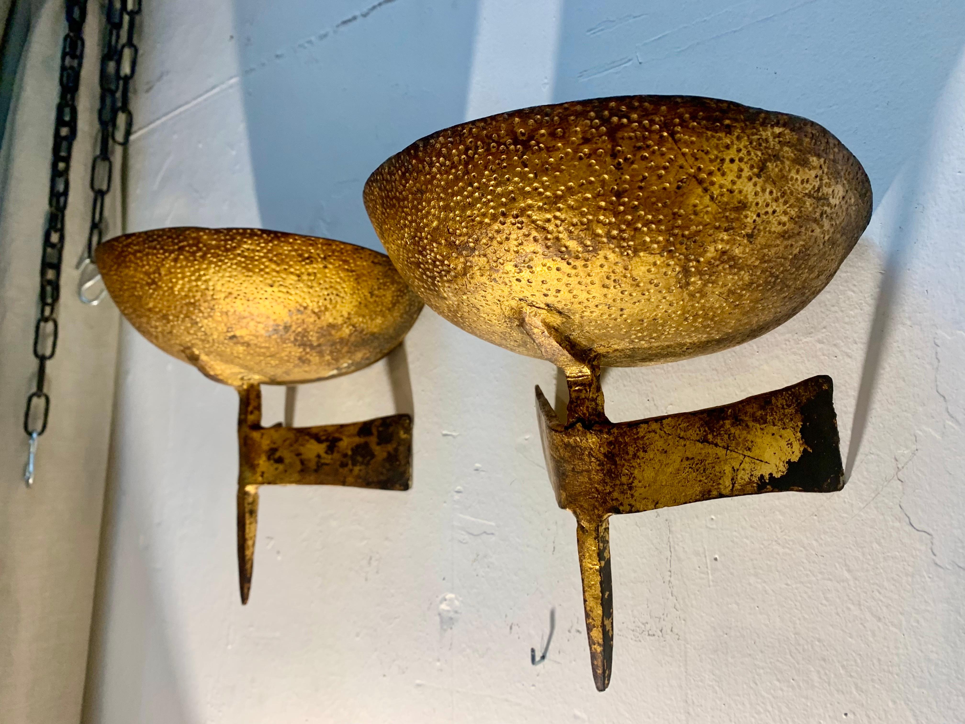 A pair of  elegant and unusual sconces for candles, in hammered iron and gold in the style of Marc du Plantier, the sconces, if you like, can be electrified.