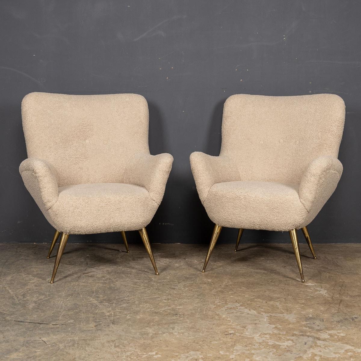 An exquisite duo of mid-20th Century Italian armchairs, featuring elegant metal legs and skillfully reupholstered in sumptuous cream boucle fabric, complete with removable seat cushions. These chairs epitomize exceptional quality, graced with a