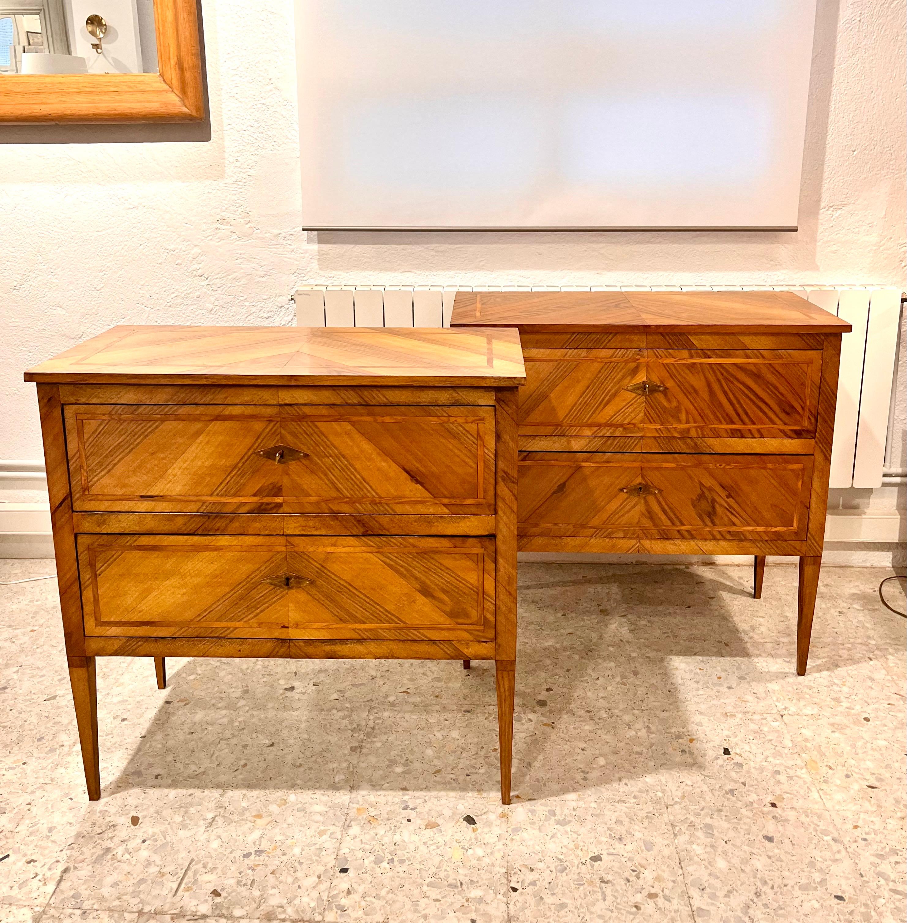 Coppia di cassettiere italiane realizzate tra la fine del XIX e l'inizio del XX secolo, in stile Biedermaier. Sono realizzati in legno di noce e l'intarsio è in legno di albero da frutto. Ognuno di essi è composto da due cassetti con serratura e