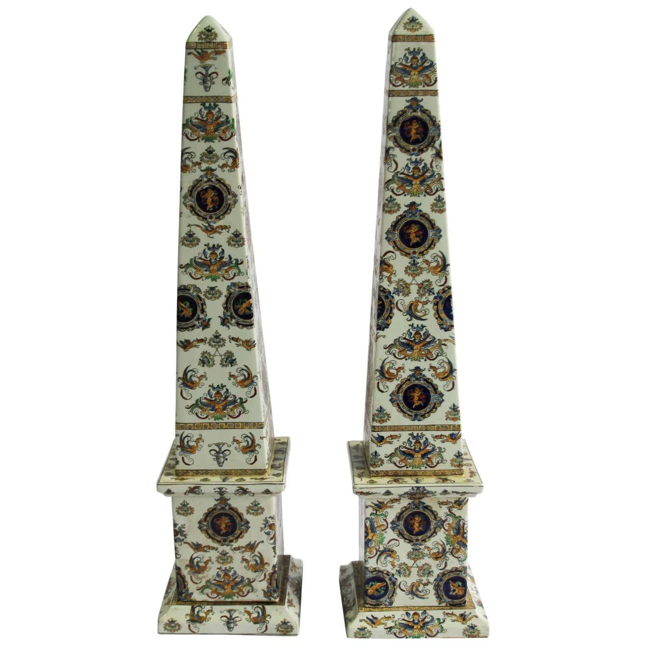 Pair of highly decorative, hand painted porcelain obelisks. Wonderful vibrant colour decoration with cherubs on plaques.