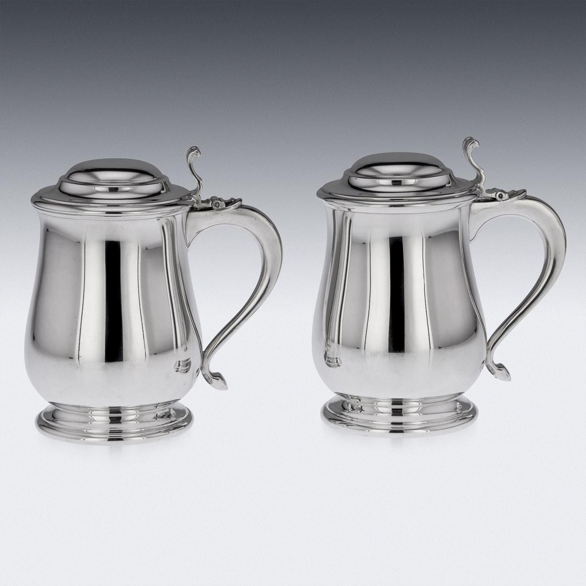 Antique 20th Century pair of Italian solid silver lidded tankards, the domed lid is applied with a cast thumb-piece, the scrolled handle terminating in a smooth point. The tankard features a bellied body on a flared foot, the sides are smooth. On