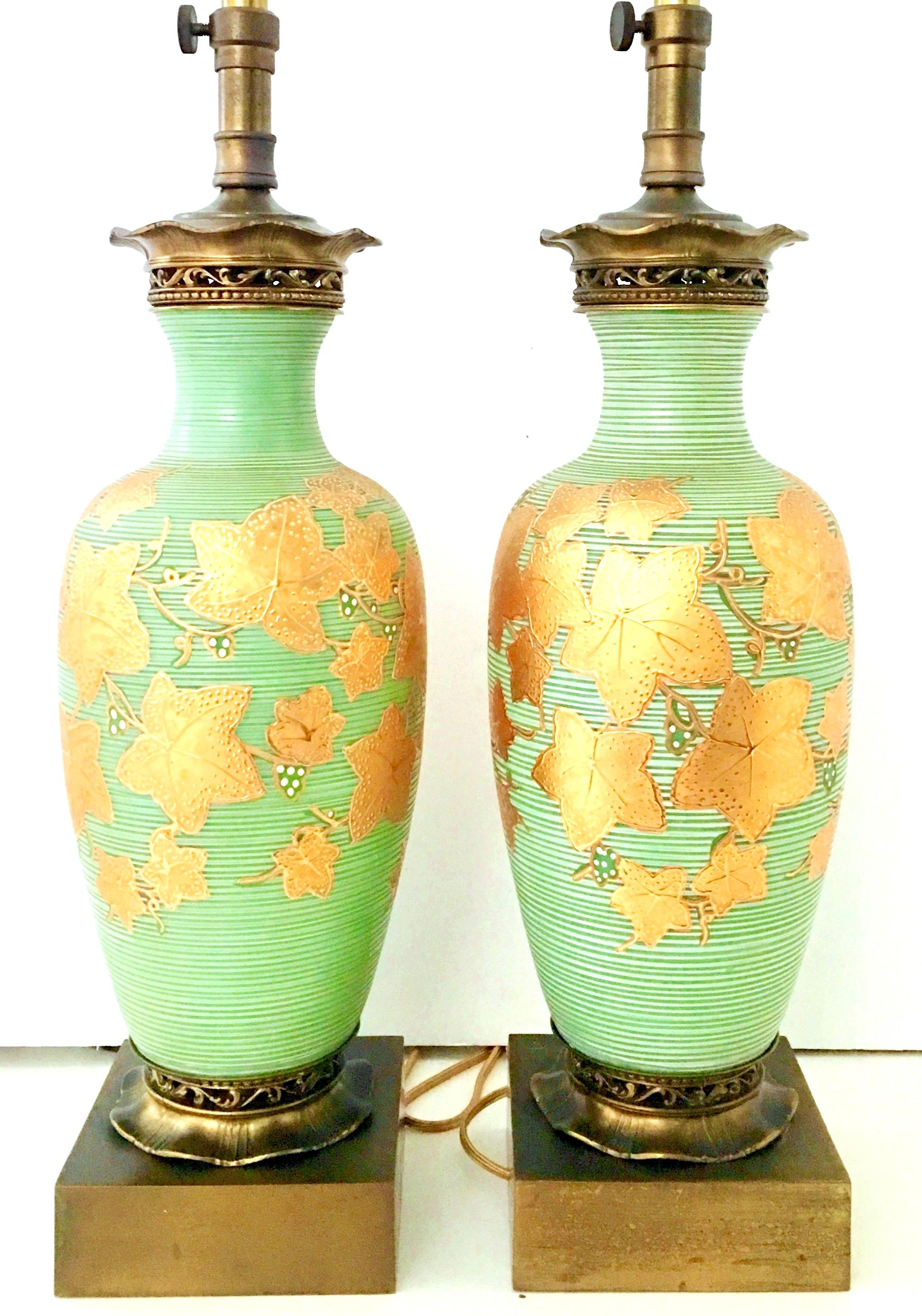 Mid-20th century pair of Italian Venetian blown art glass, 22-karat gold and brass hand painted table lamps. These finely crafted and unique lamps are executed in celery green and white opaque swirled Venetian blown glass with thick, raised 22-karat