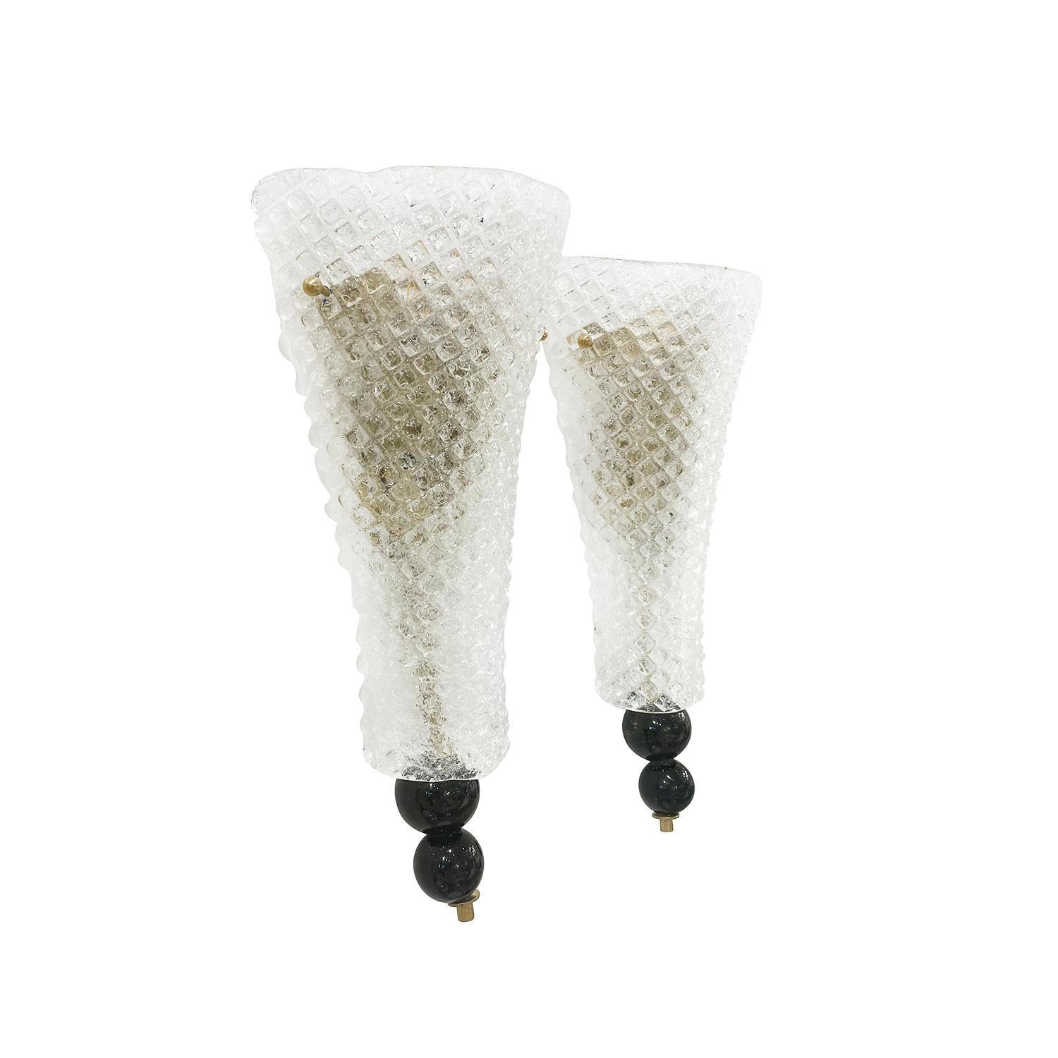 Paire de petites appliques tulipes en verre de Murano fumé, soufflé à la main, en bon état. Chacune des appliques est caractérisée par deux sphères noires qui sont soutenues par une tige flexible en laiton, dotée d'une douille à deux lumières. Les
