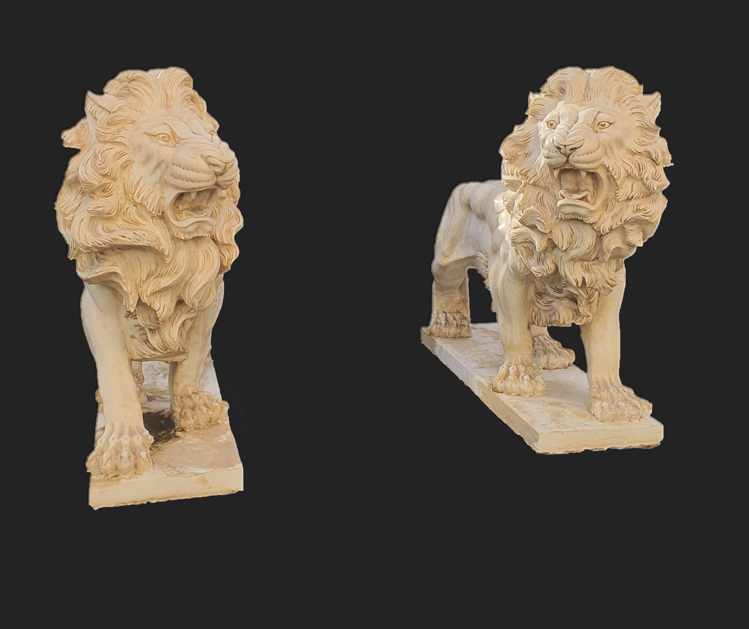 Elegantes Paar statuarischer Skulpturen aus weißem Marmor, die Löwen darstellen. Fein geschnitzte Skulptur bis ins kleinste Detail.